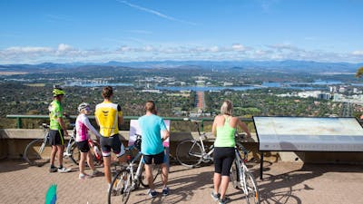 5 cyclists stand with their bikes behind the Marion Mahony Griffin View handrail.