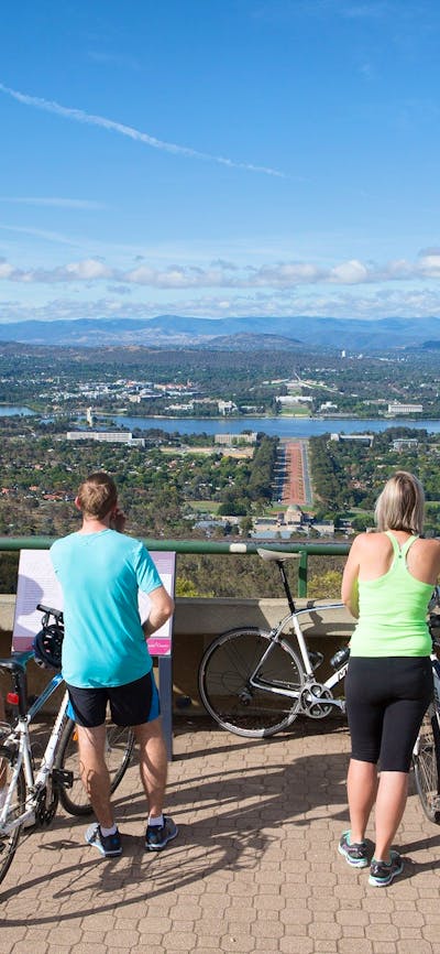 5 cyclists stand with their bikes behind the Marion Mahony Griffin View handrail.