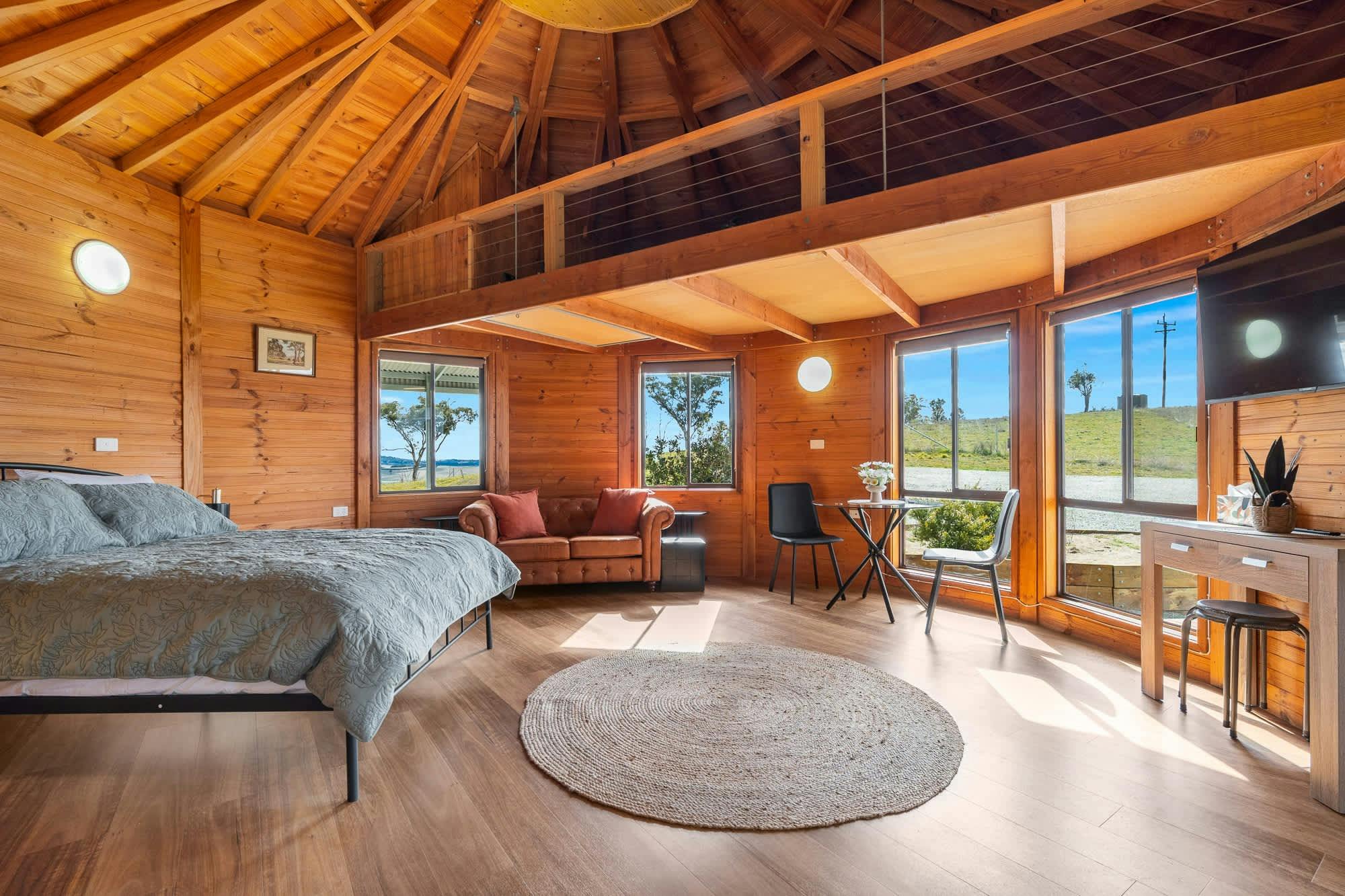 퀸 사이즈 침대 소파 창문, 2인용 식탁과 의자, TV가 보입니다.