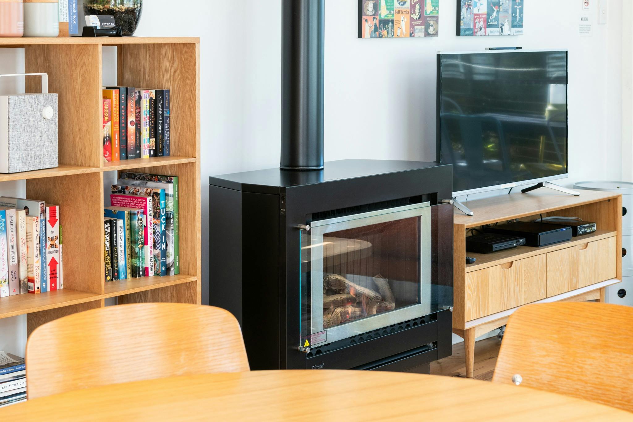 Living area with Rinnai gas fireplace, TV, books and entertainment options.