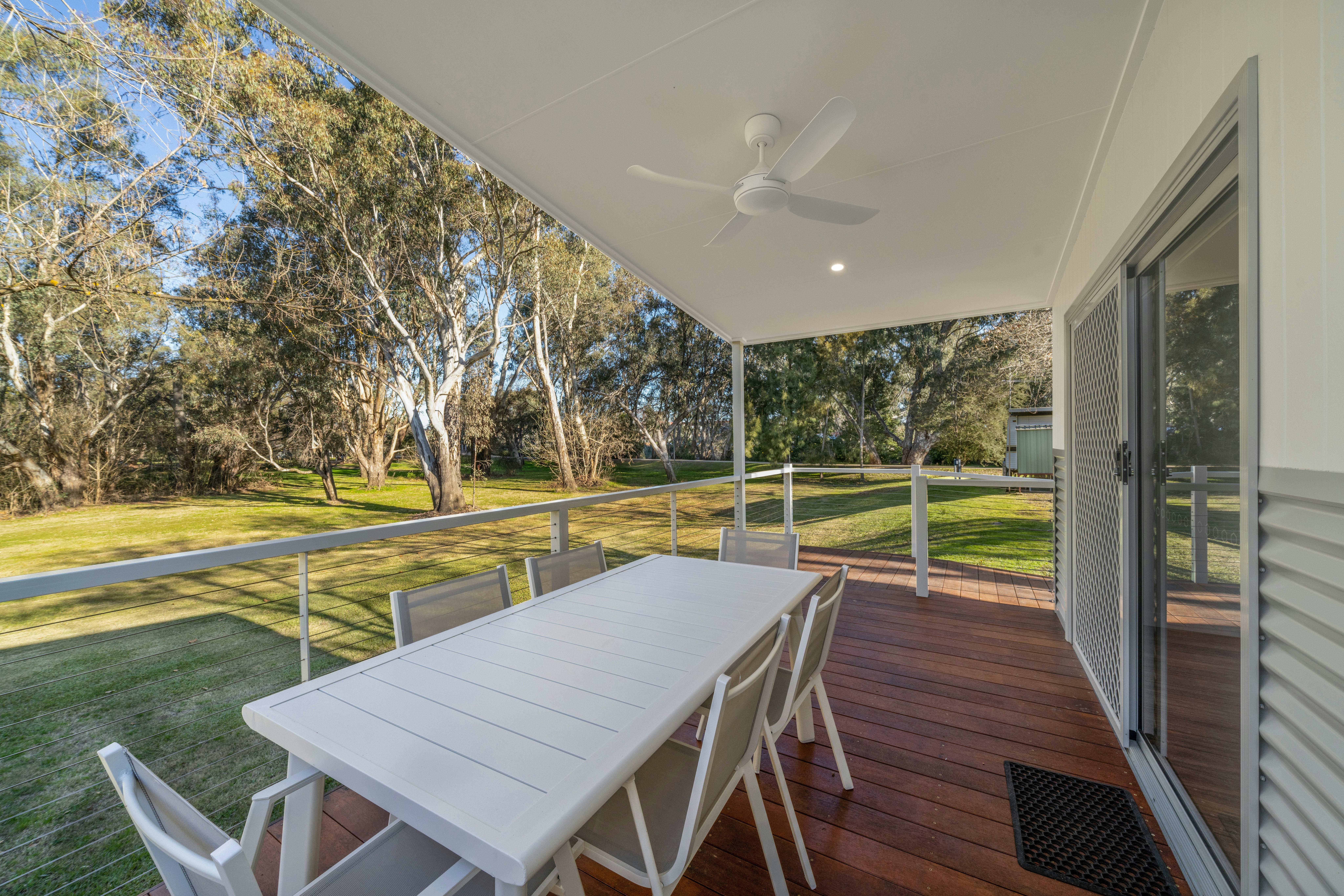 Premium cabin deck showing the outdoor dining table and views to Wangaratta