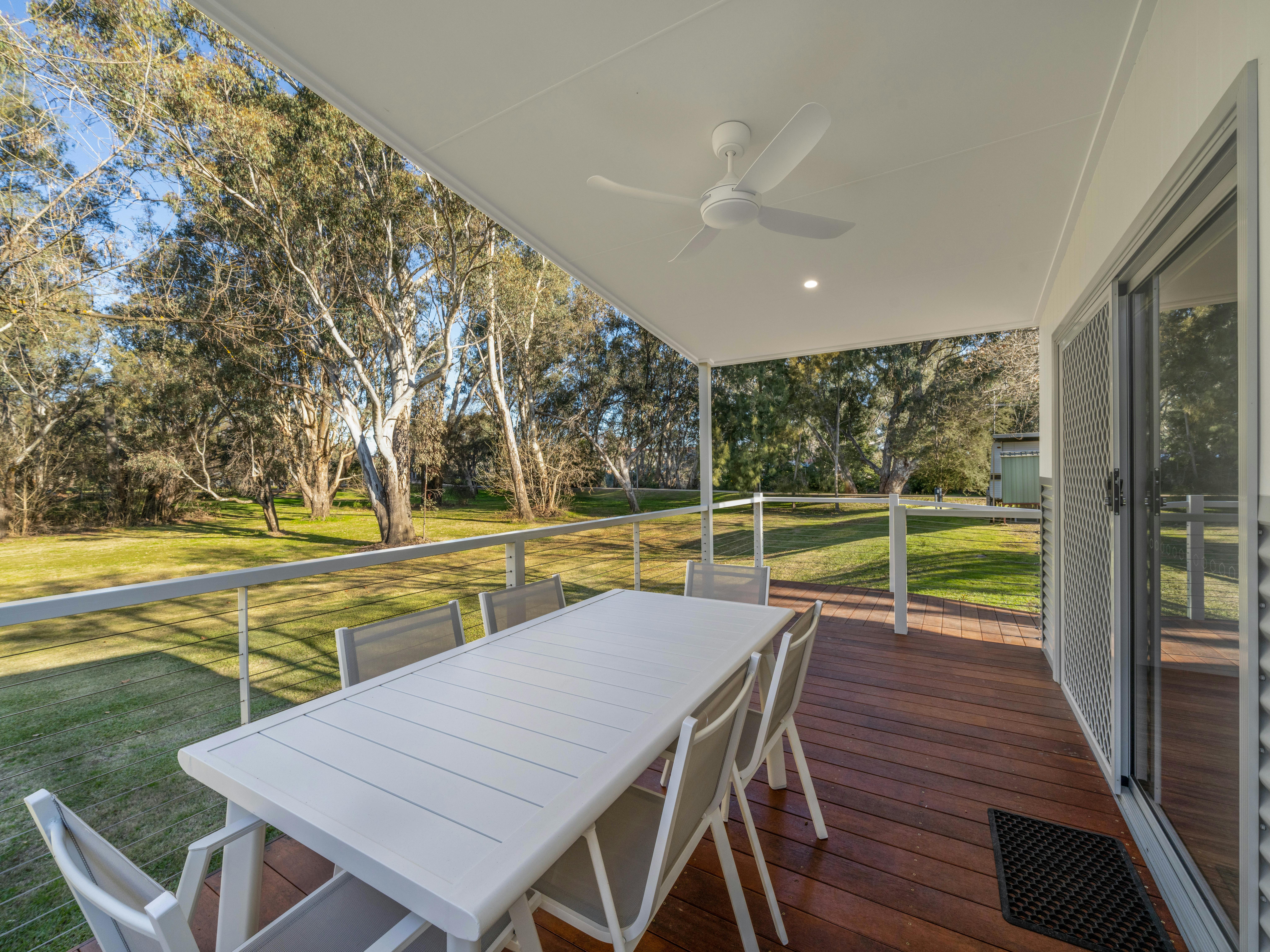 Premium cabin deck showing the outdoor dining table and views to Wangaratta