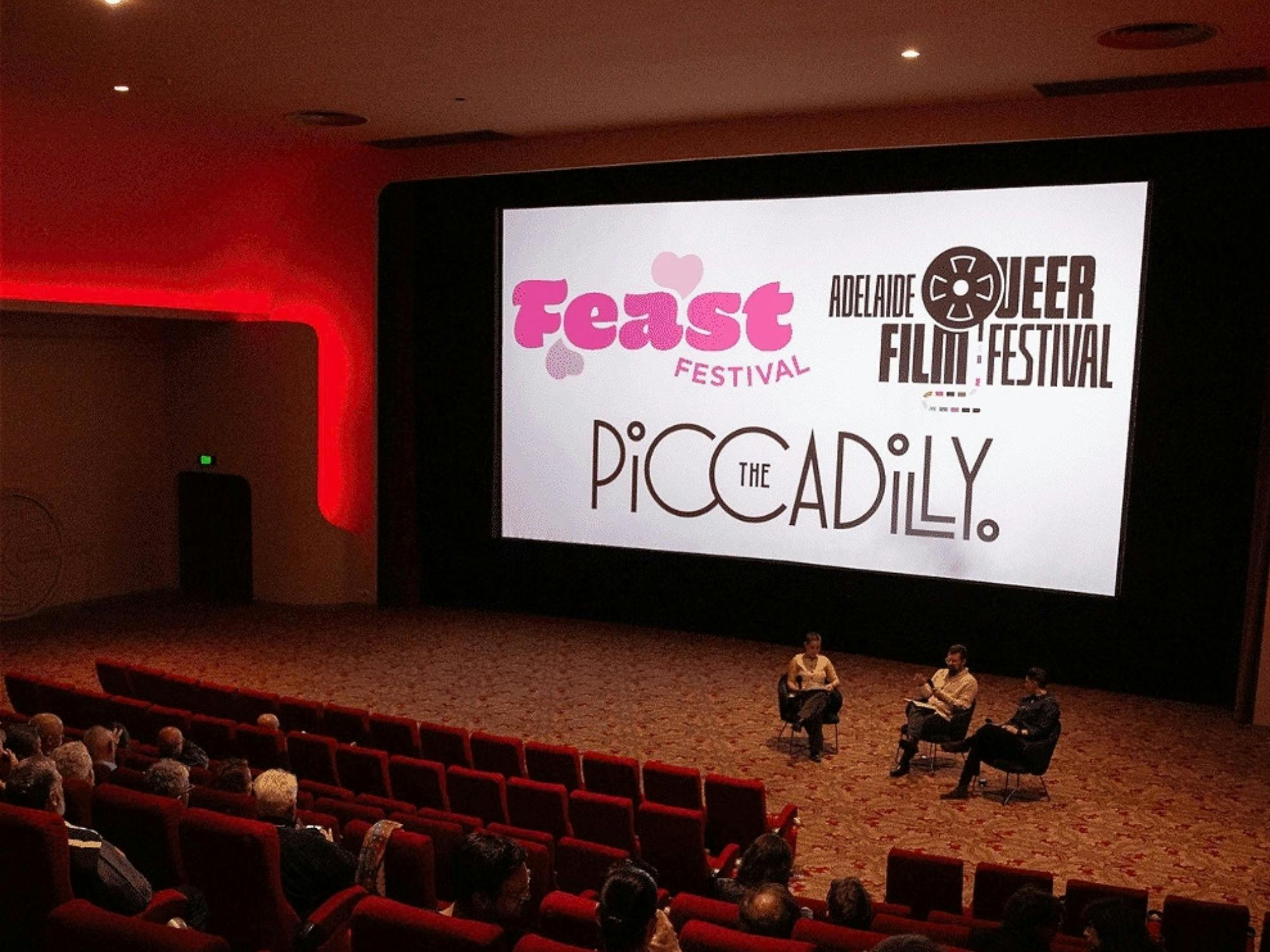 Photo of cinema with screen showing "Feast, AQFF, and Piccadily Cinema", with an audience in seats