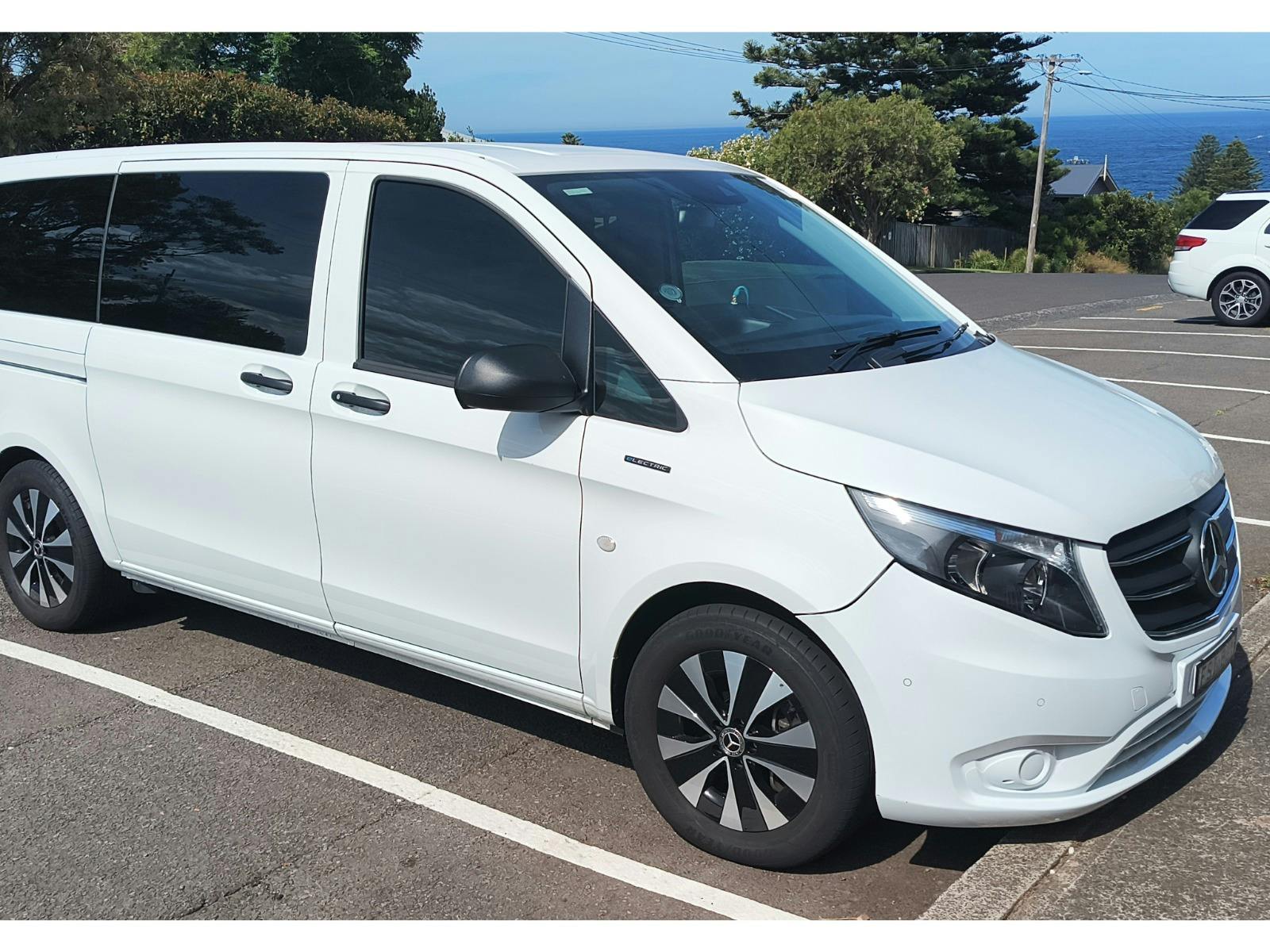 A white van parked in front of ocean views.