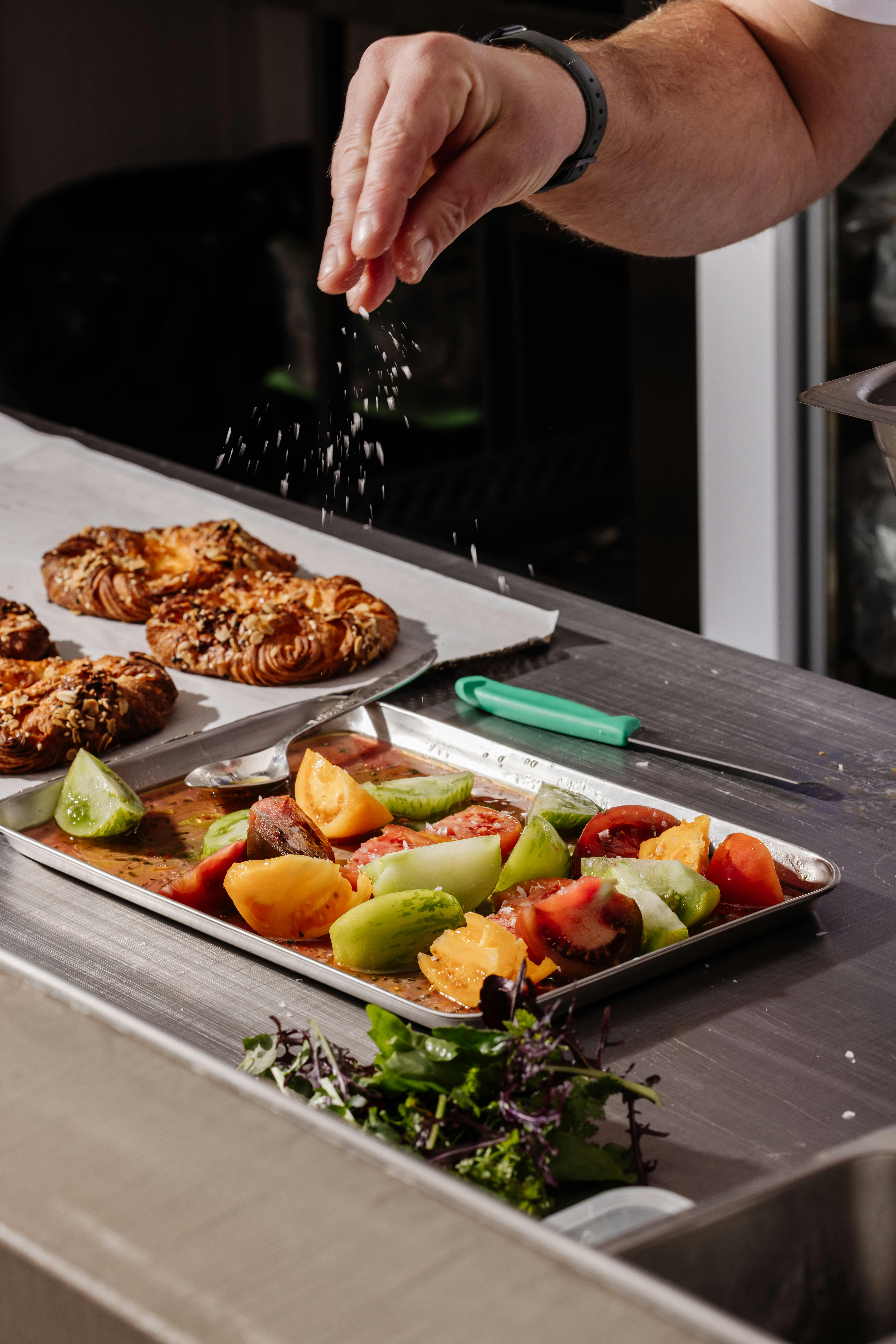 Sprinkling salt on tomatoes for pastries at Crumb