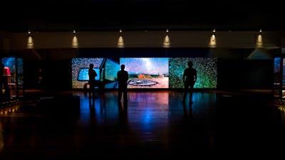 Dark gallery space with shadows and outlines of people in the space