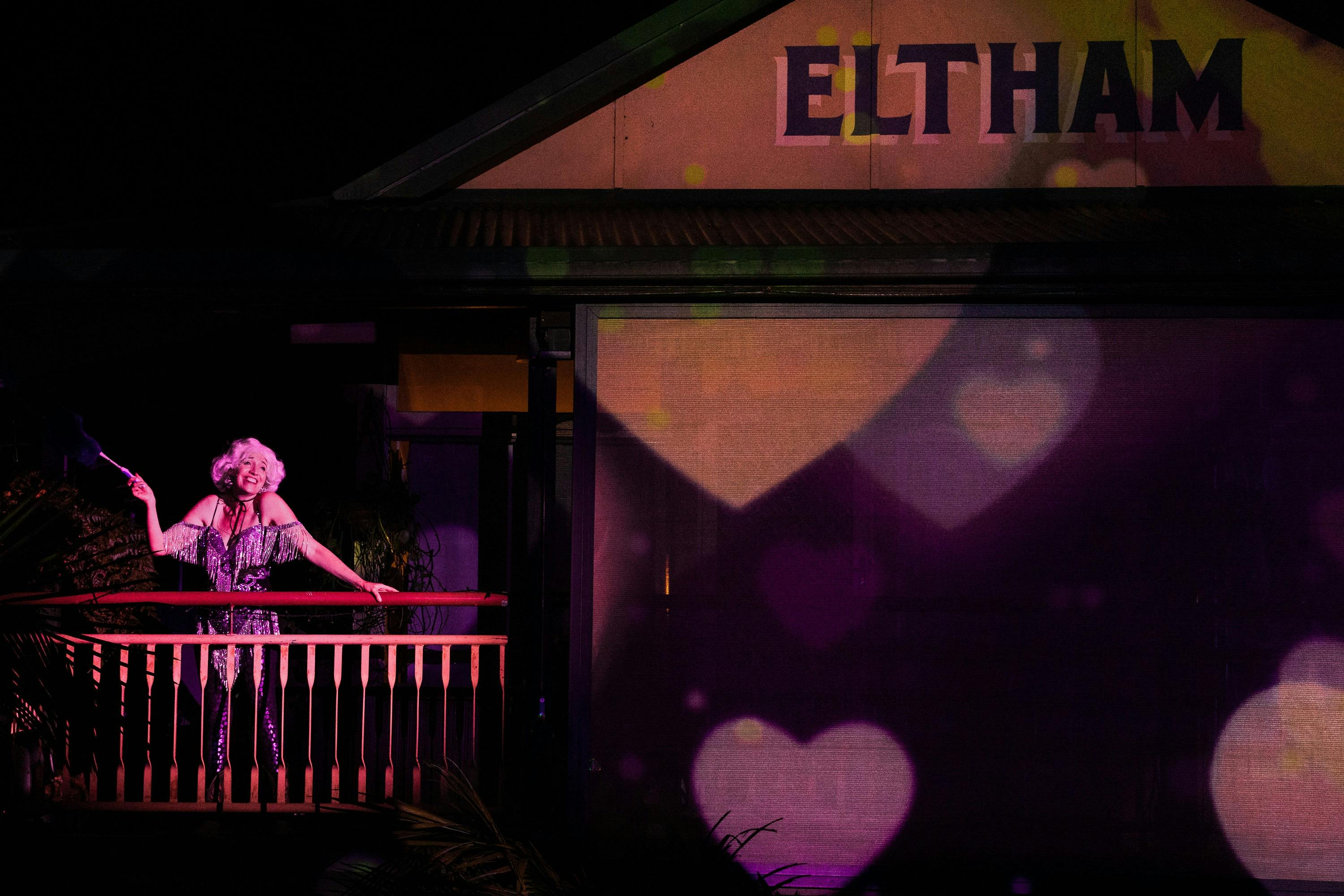 A woman on a balcony of the Eltham Hotel