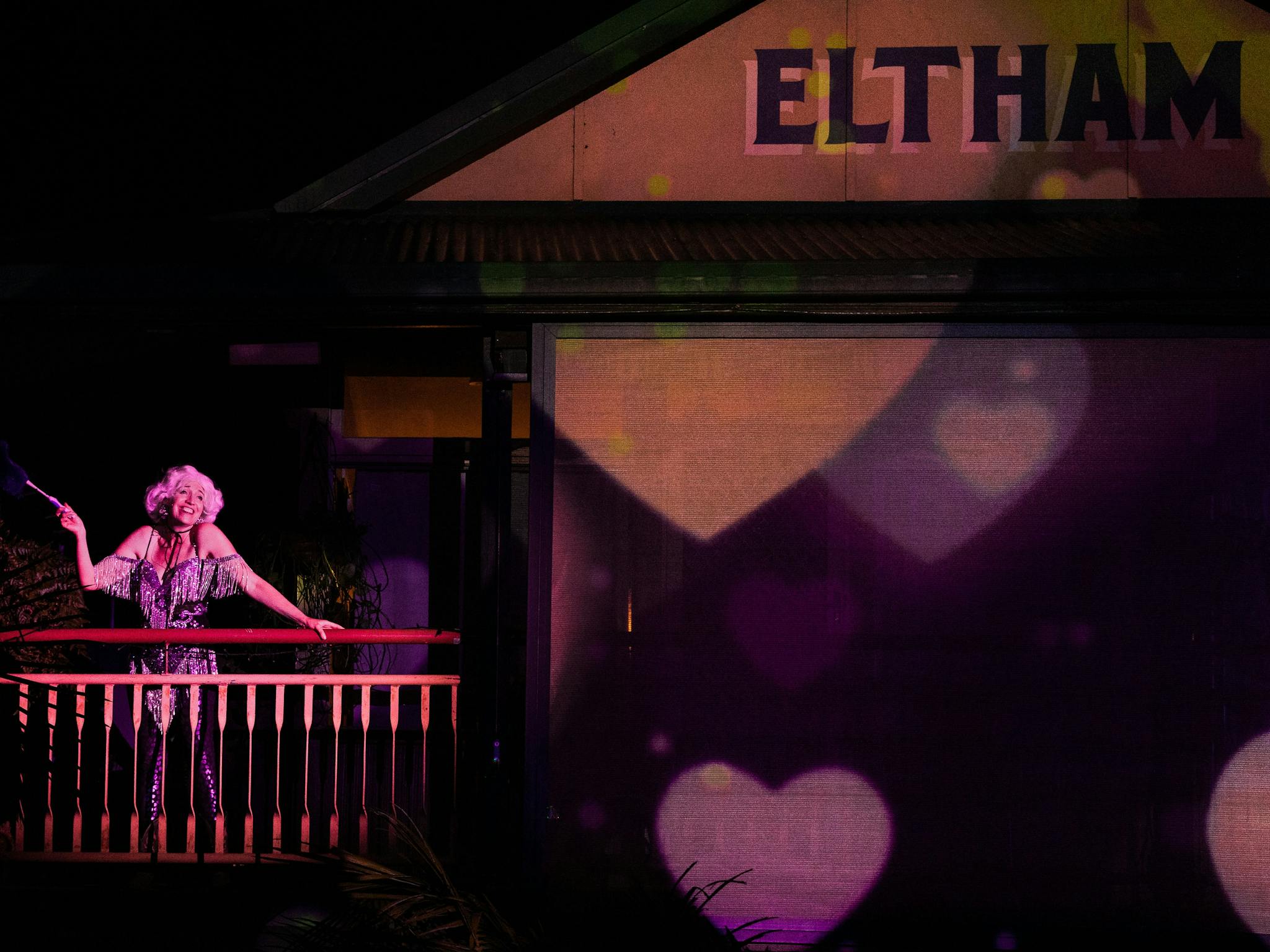 A woman on a balcony of the Eltham Hotel