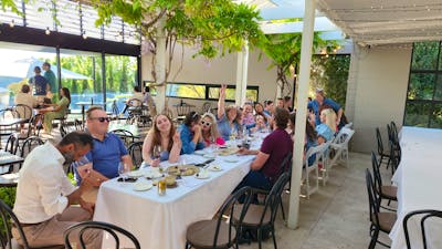 A group of individuals gathered around a table, engaged in conversation and enjoying a meal together