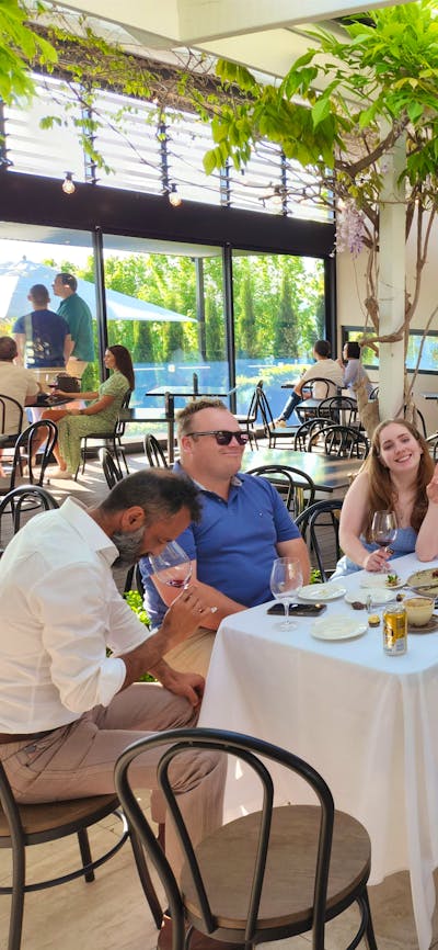 A group of individuals gathered around a table, engaged in conversation and enjoying a meal together