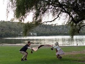 preparing a picnic rug on the grass
