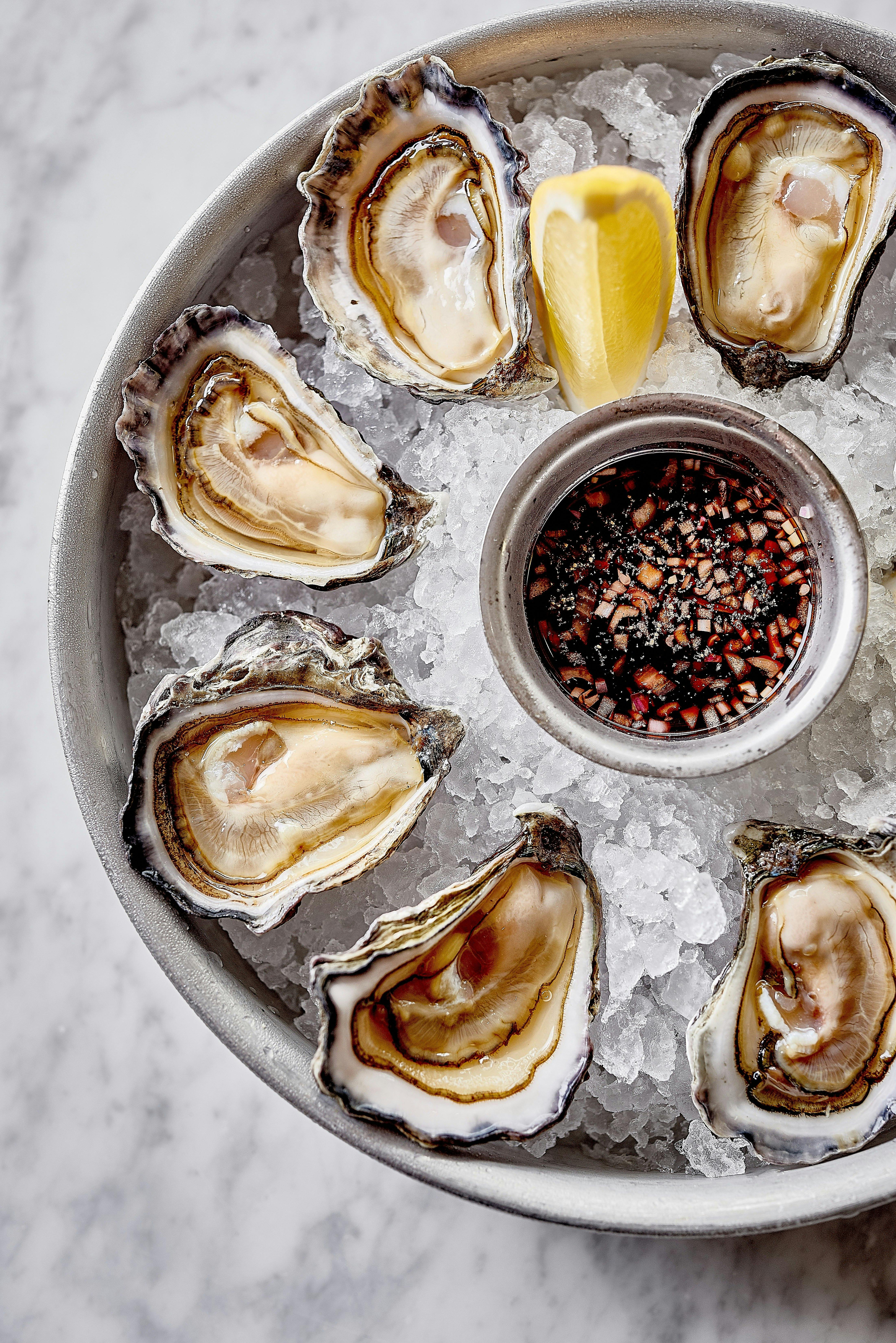 Raw shucked oysters on ice with pink mignonette dressing