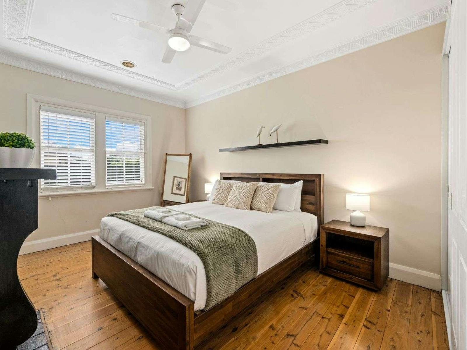 Main bedroom with king bed, side tables, shelf above the bed