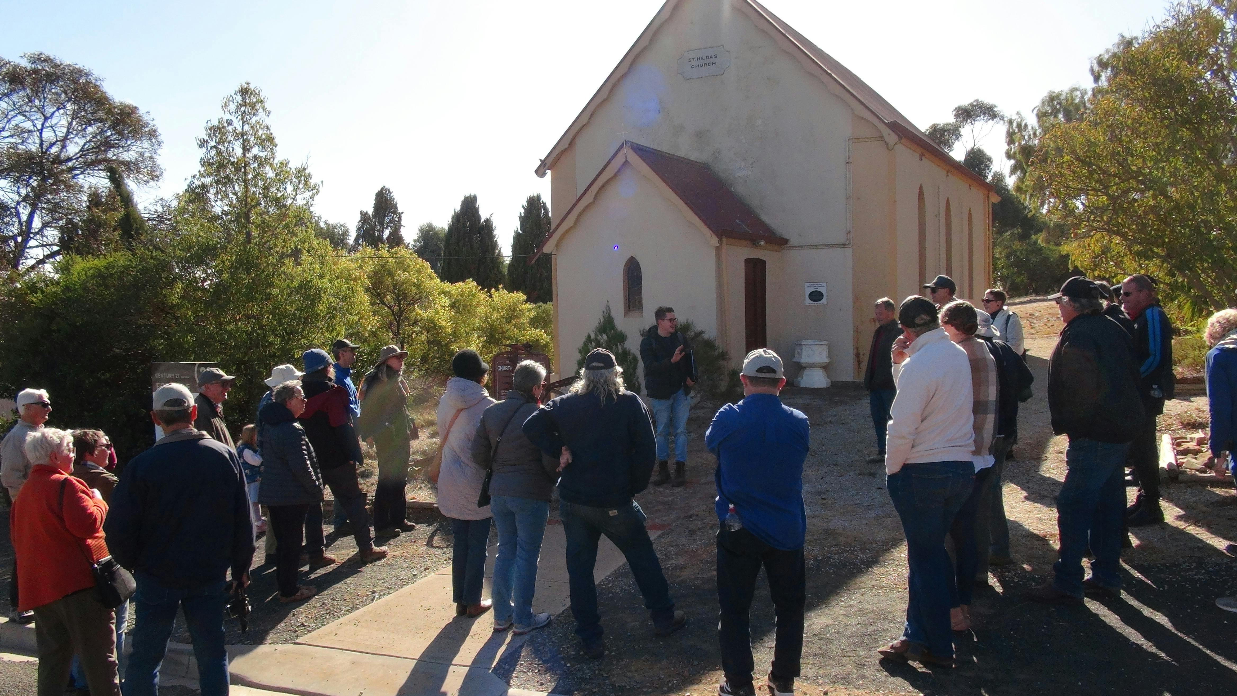 Tour group gathered around a church building in Eudunda.