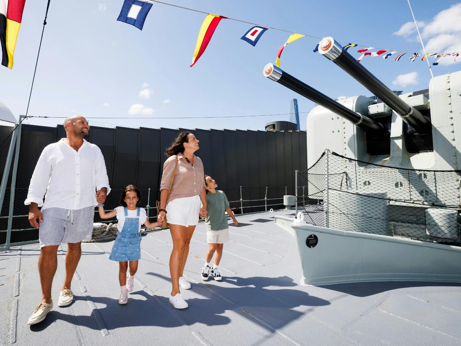 A family aboard HMAS Vampire looking at the guns