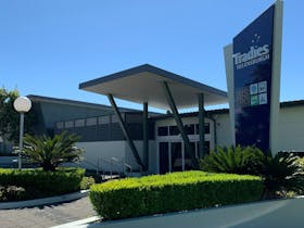 Front exterior of the Tradies Helensburgh club including gardens and signage