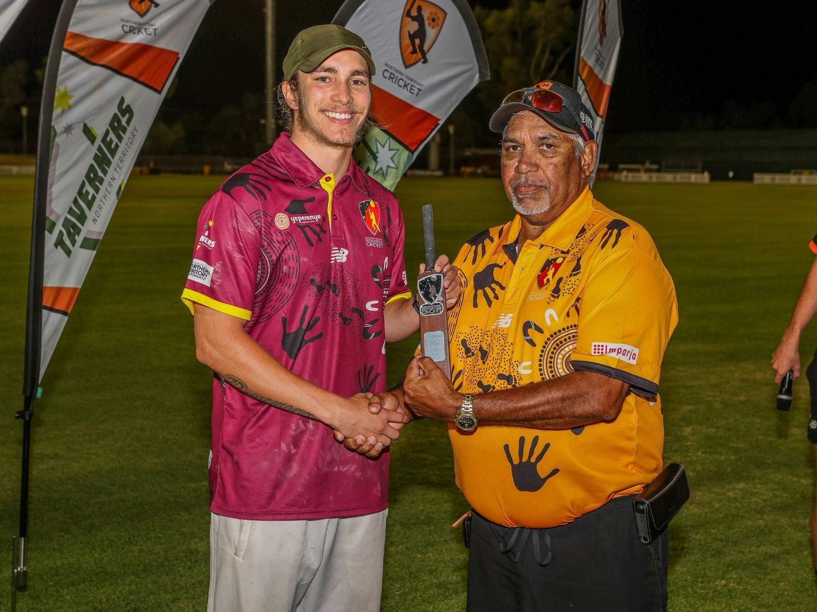 Two Indigenous Males holding mini cricket bat trophy
