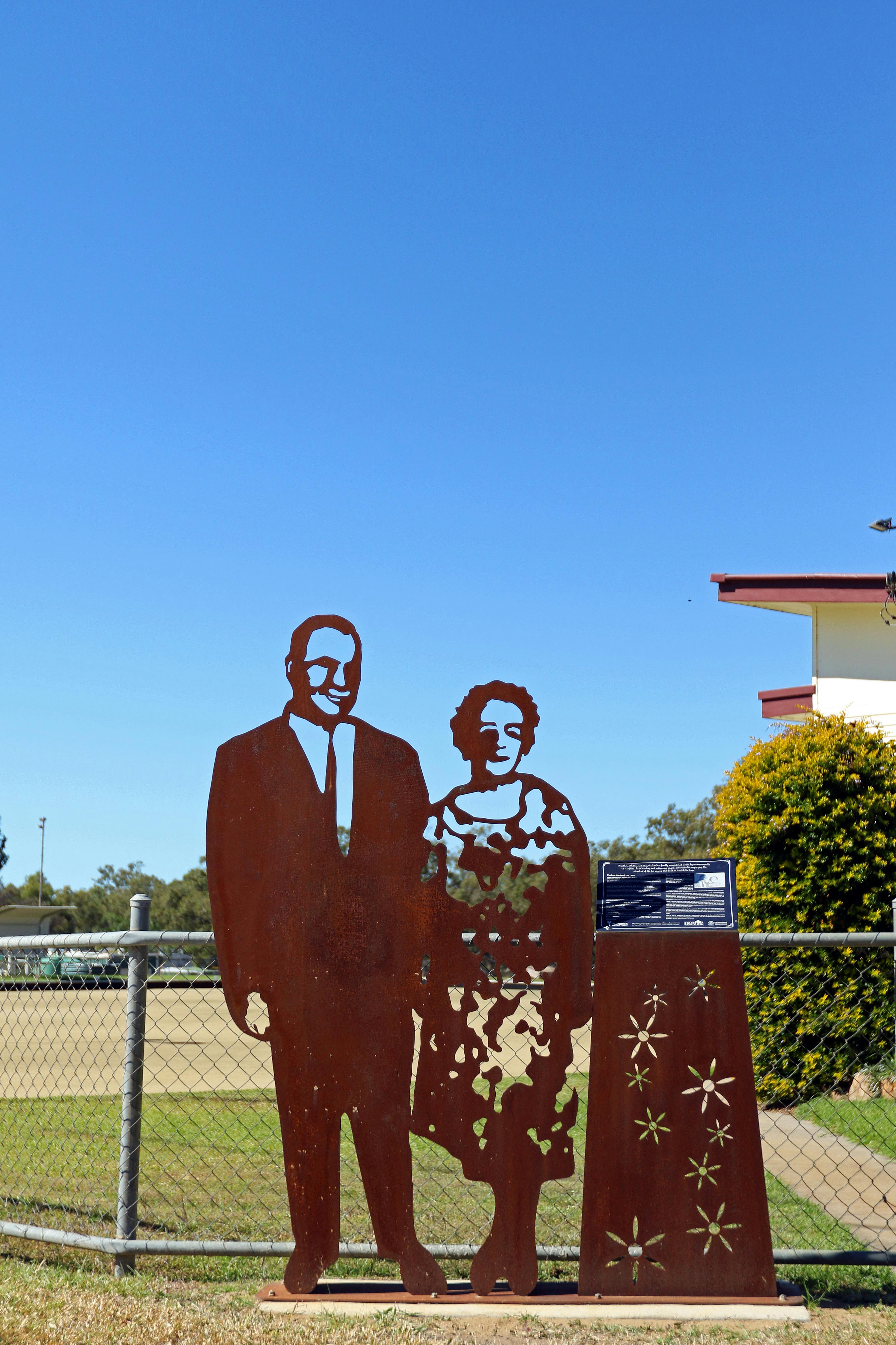 A metal lasercut sculpture of a man in a suit and a woman in a floral dress
