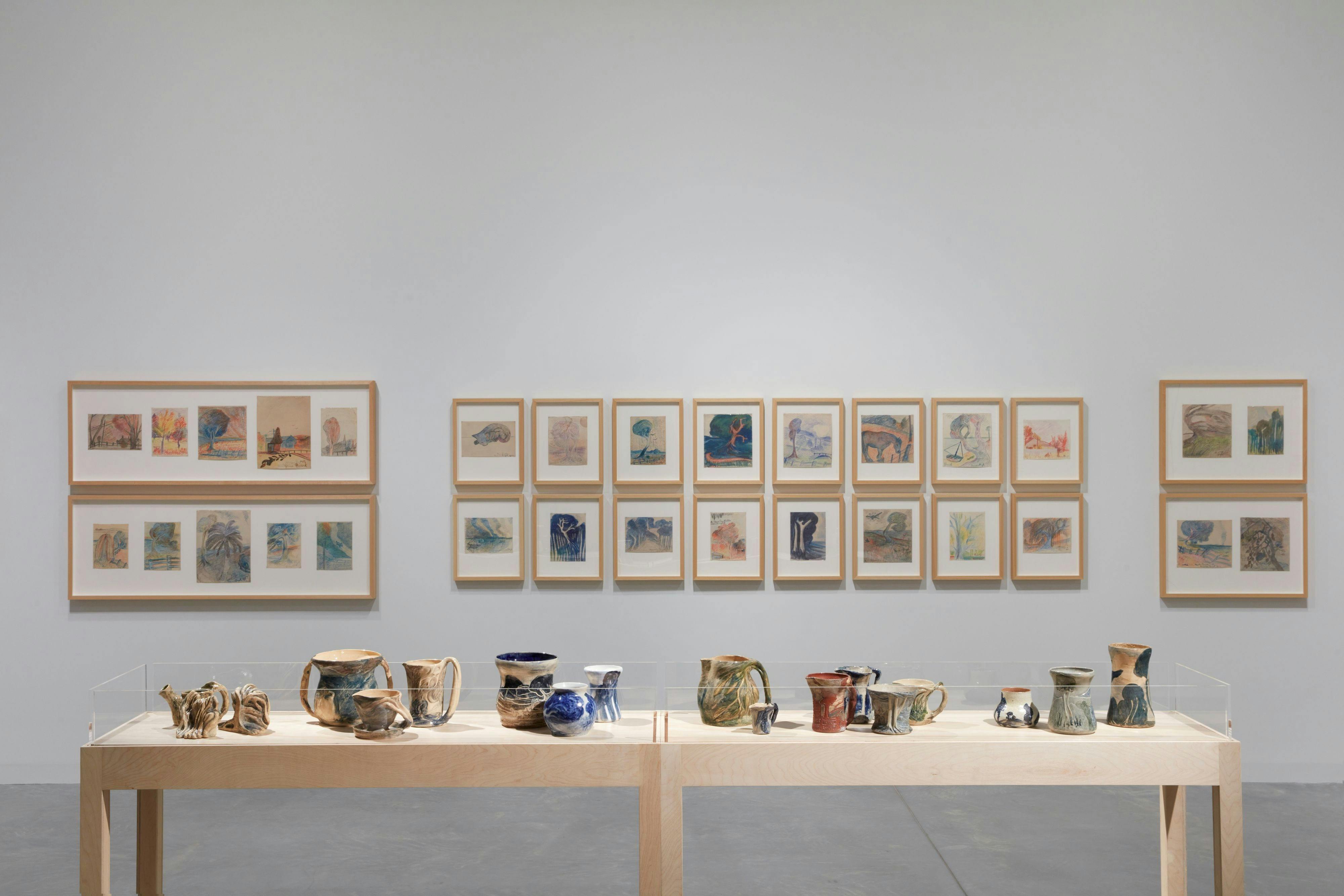 Gallery installation with pottery pieces and drawings.