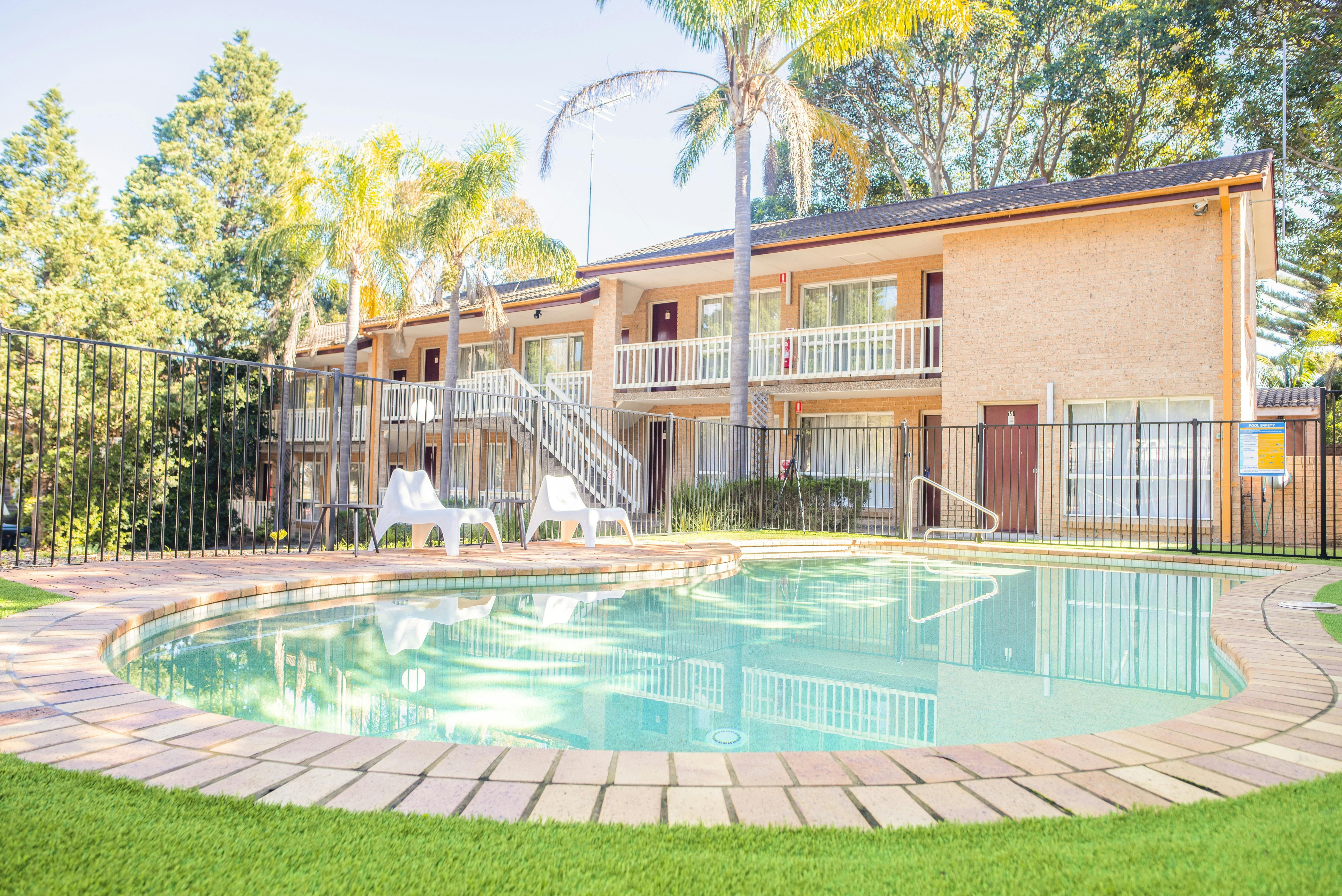Outdoor swimming pool at Sutherland Motel,  two-story blonde brick motel