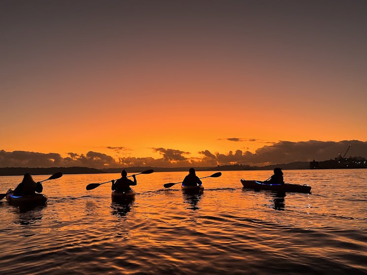 kayakers on the water at glowing sunrise
