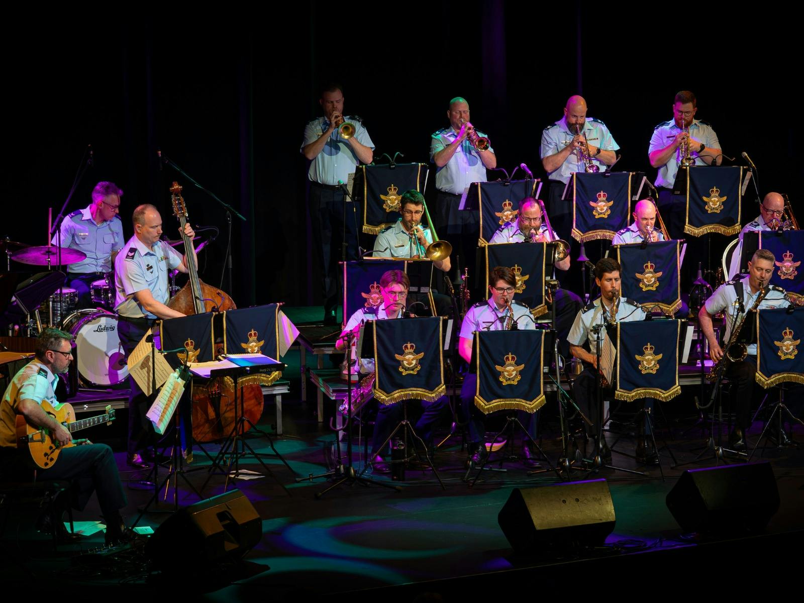 multiple people  on stage playing musical instruments