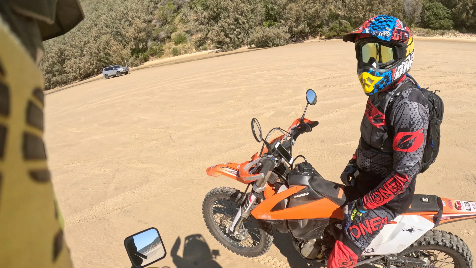 A peron sits on a dirt bike at the beach