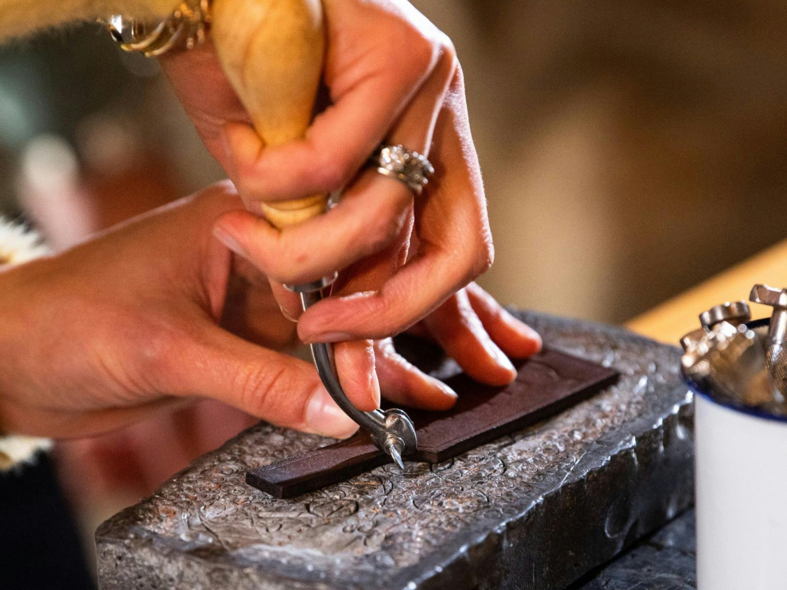Close up of hands making leather keyring