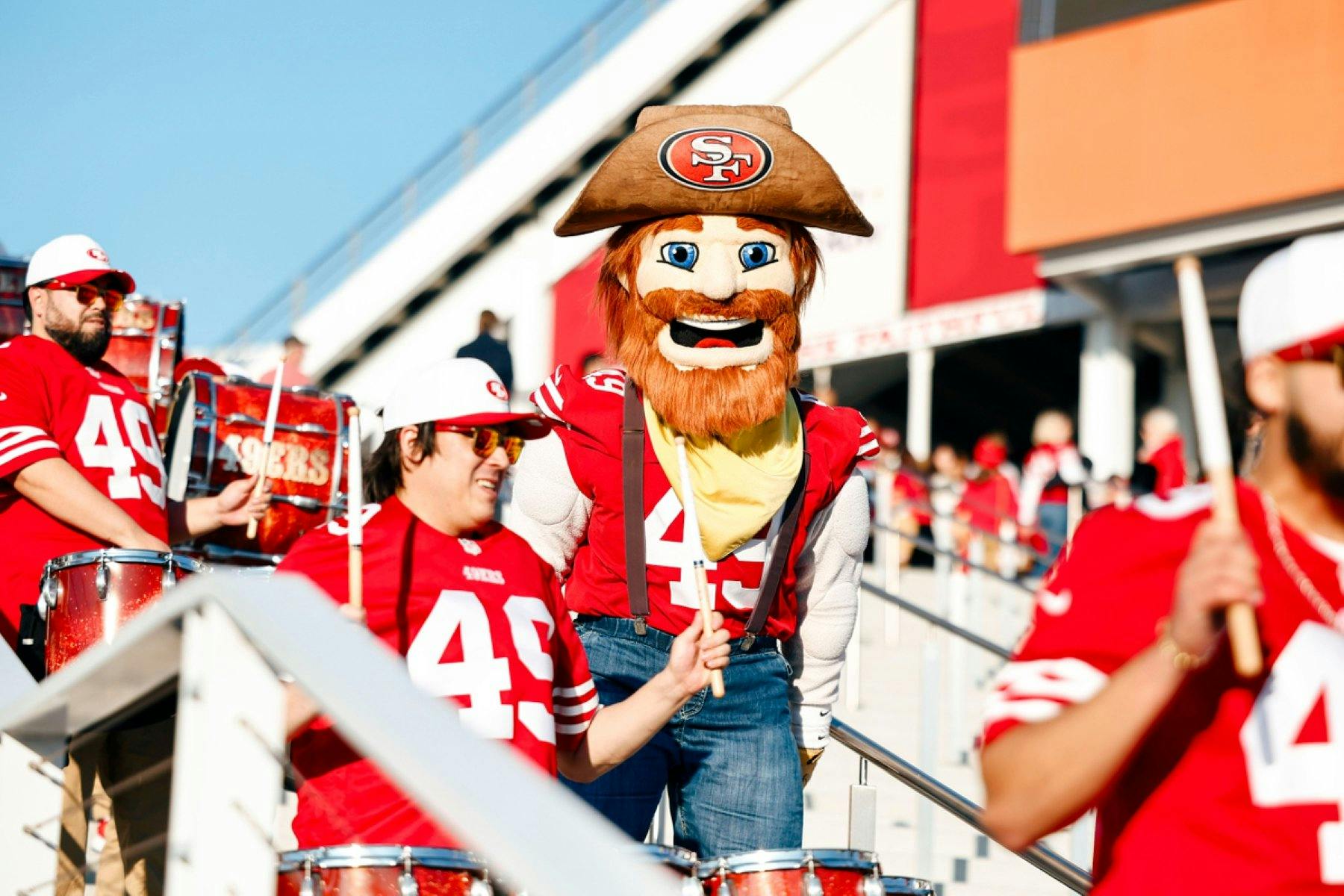 Mascot Sourdough Sam among fans wearing red 49ers jerseys