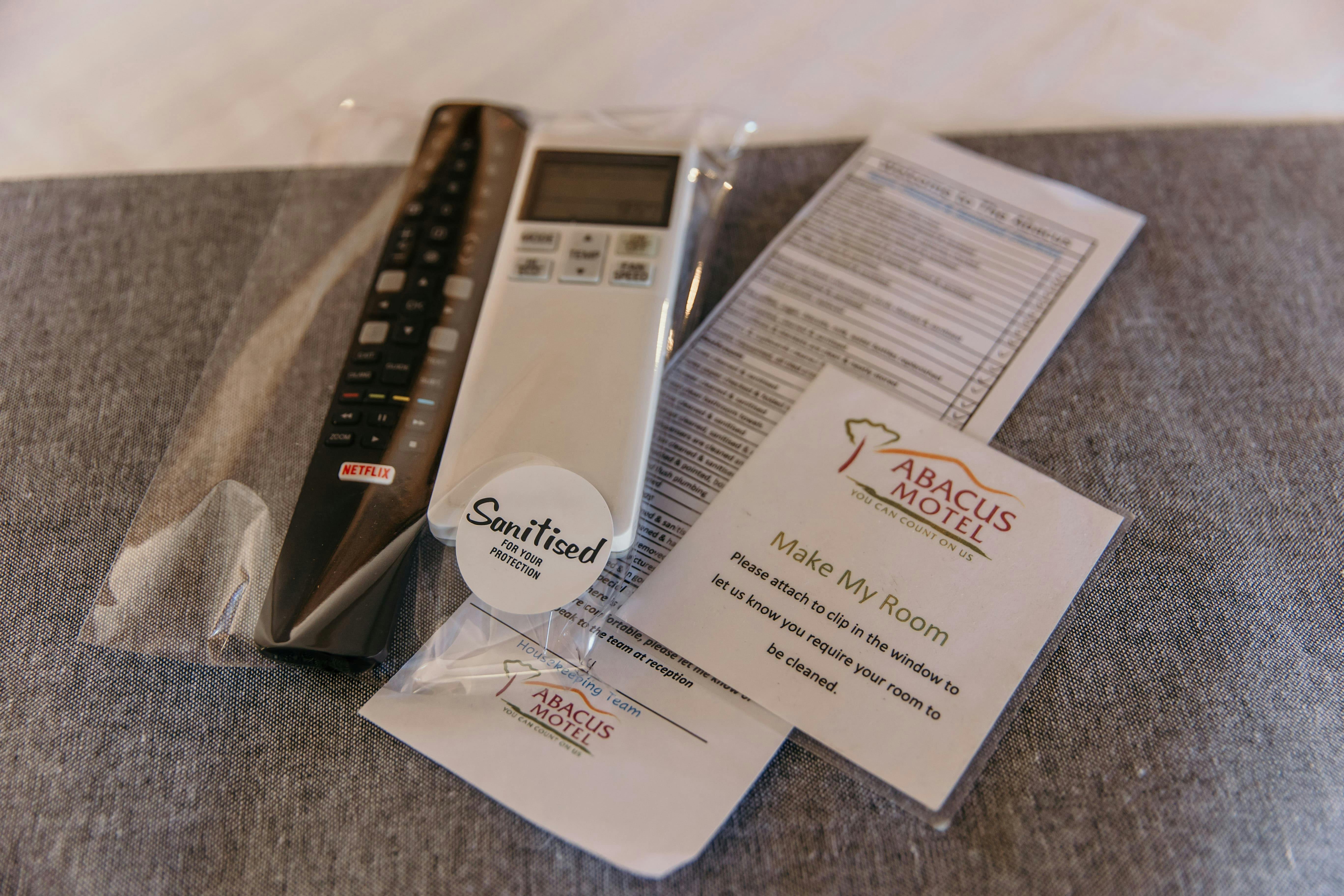 Sanitised and sealed remotes with motel information.