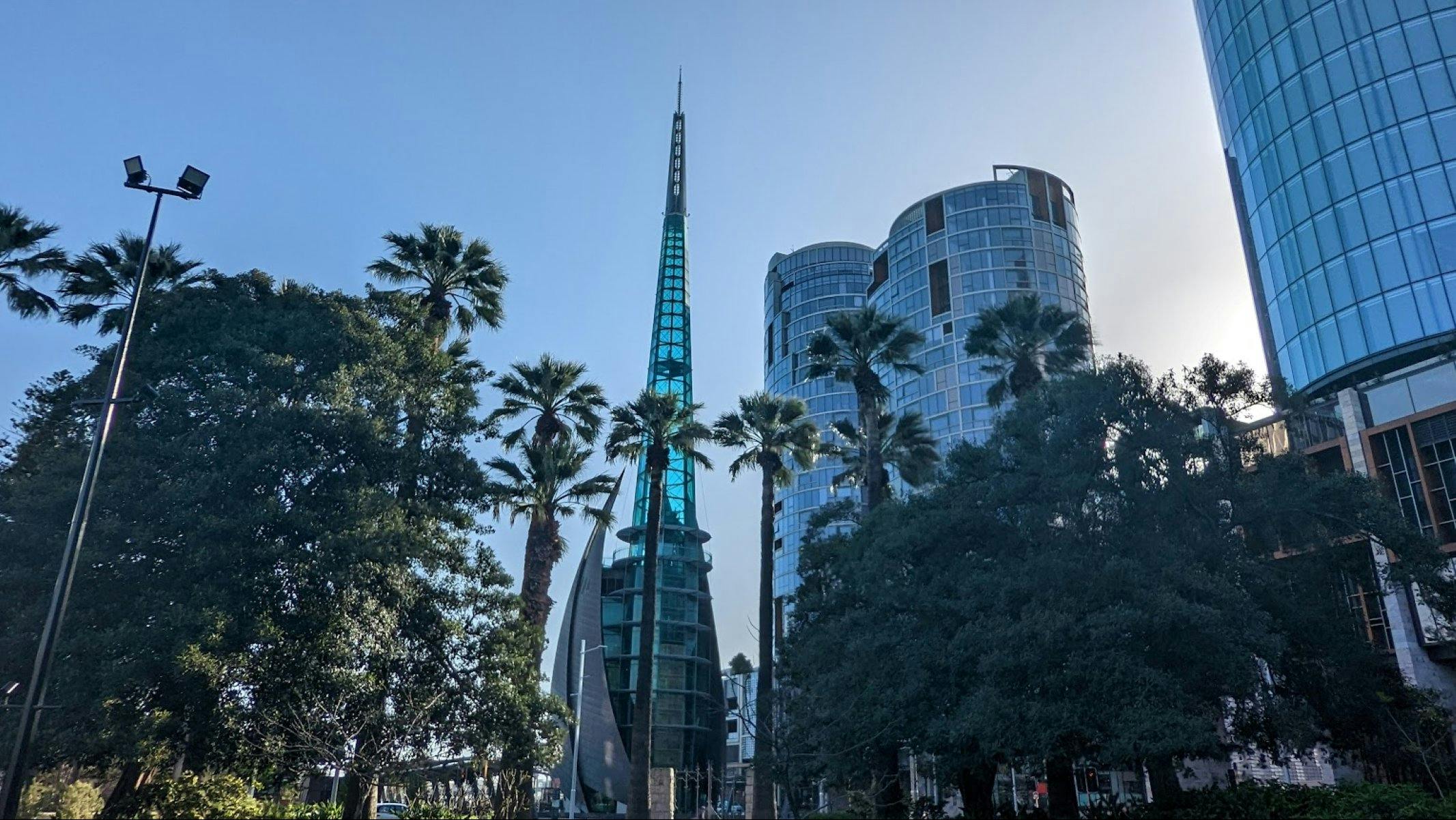Swan Bell Tower surrounded by palm trees at sunrise