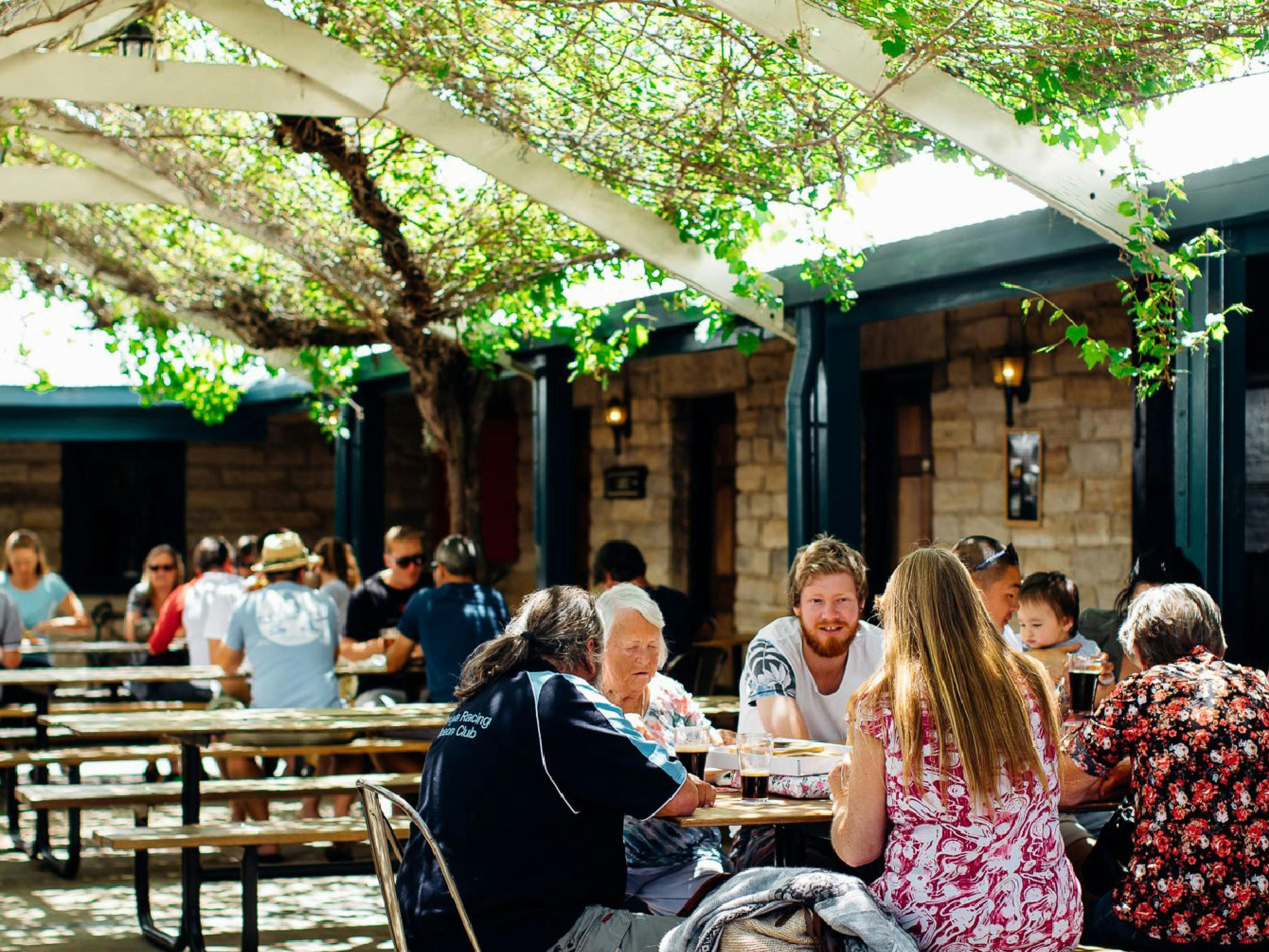 Groups of people sitting eating and drinking outside