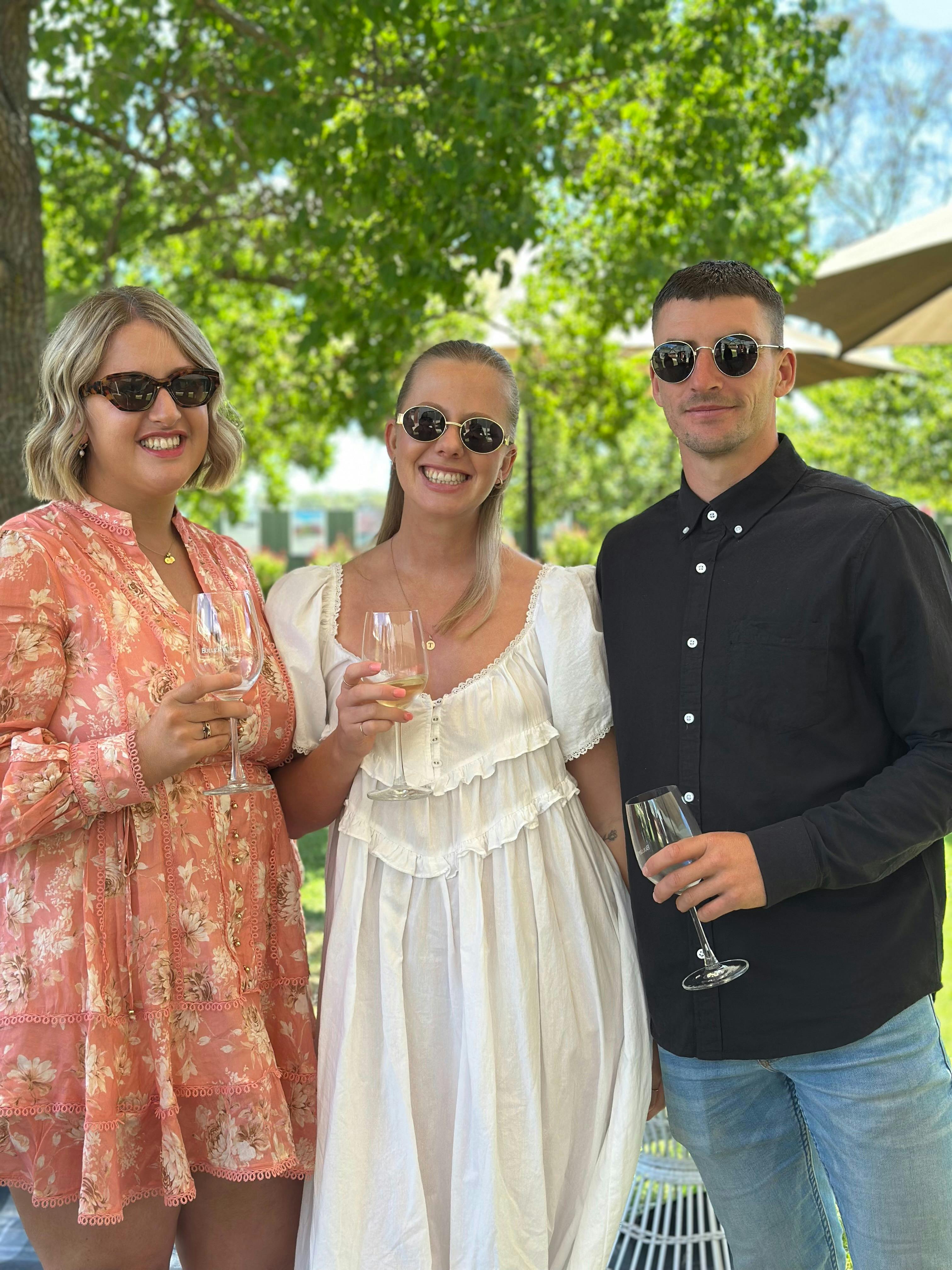3 people smiling holding wine glass