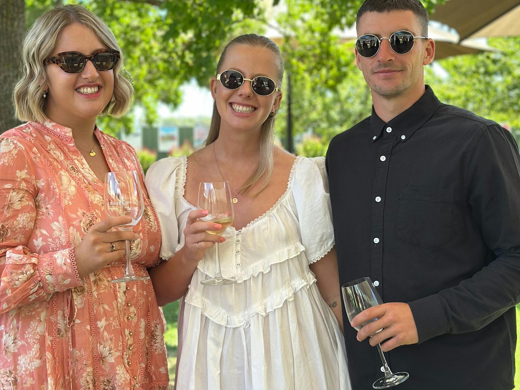 3 people smiling holding wine glass