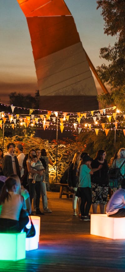 Outdoor evening festival with colourful bunting and string lights.