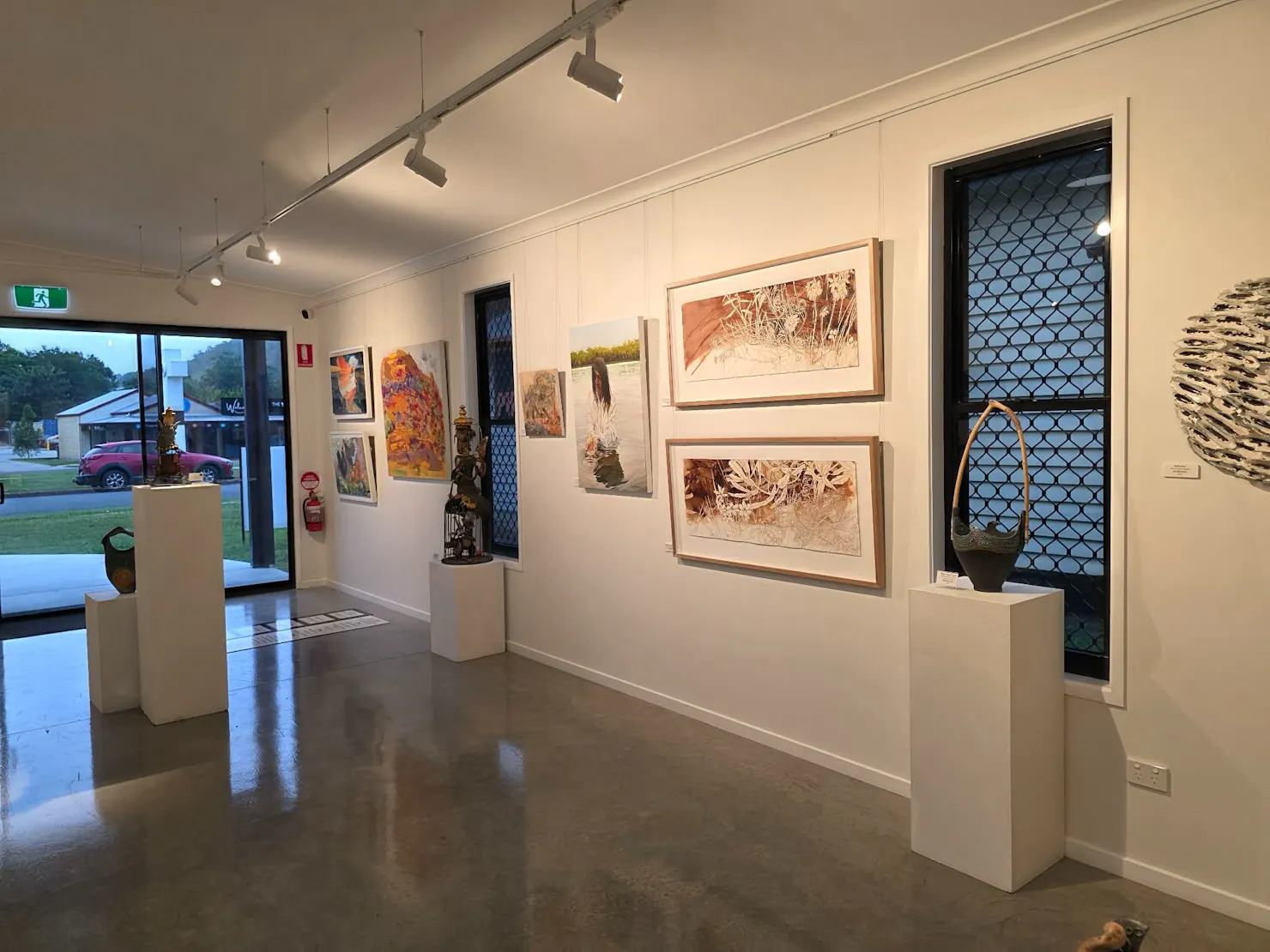 Sliding door entry to art gallery with artworks on wall