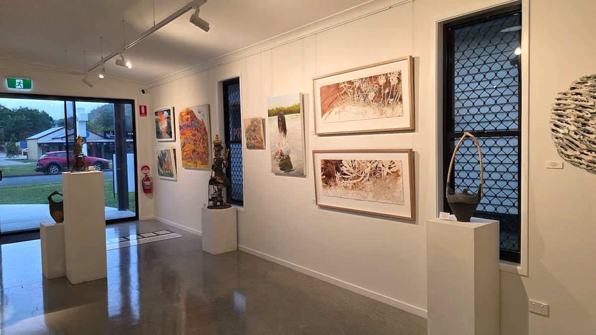 Sliding door entry to art gallery with artworks on wall