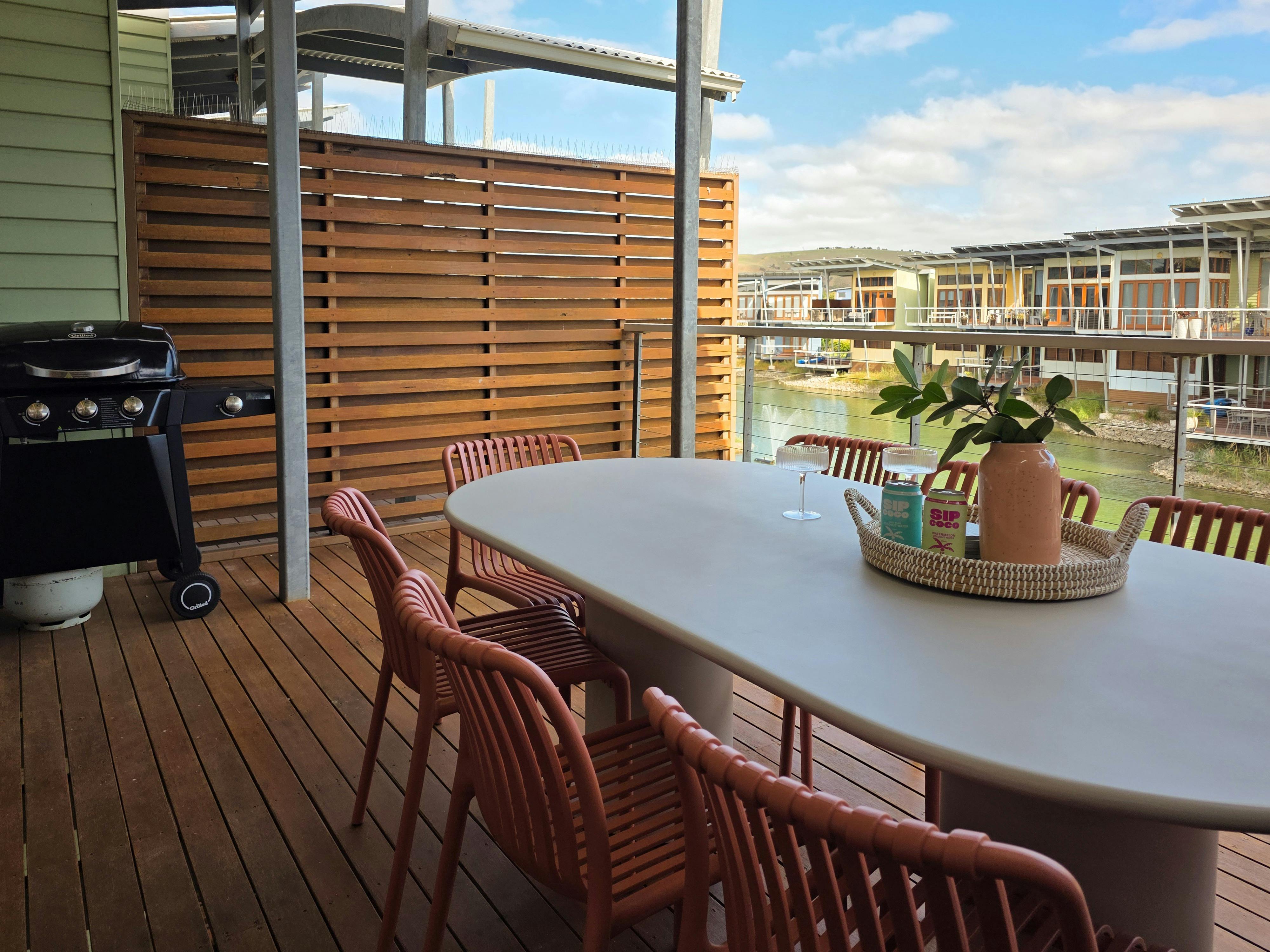 Outdoor dining table and chairs with BBQ overlooking the lagoon, creating a peaceful space to unwind