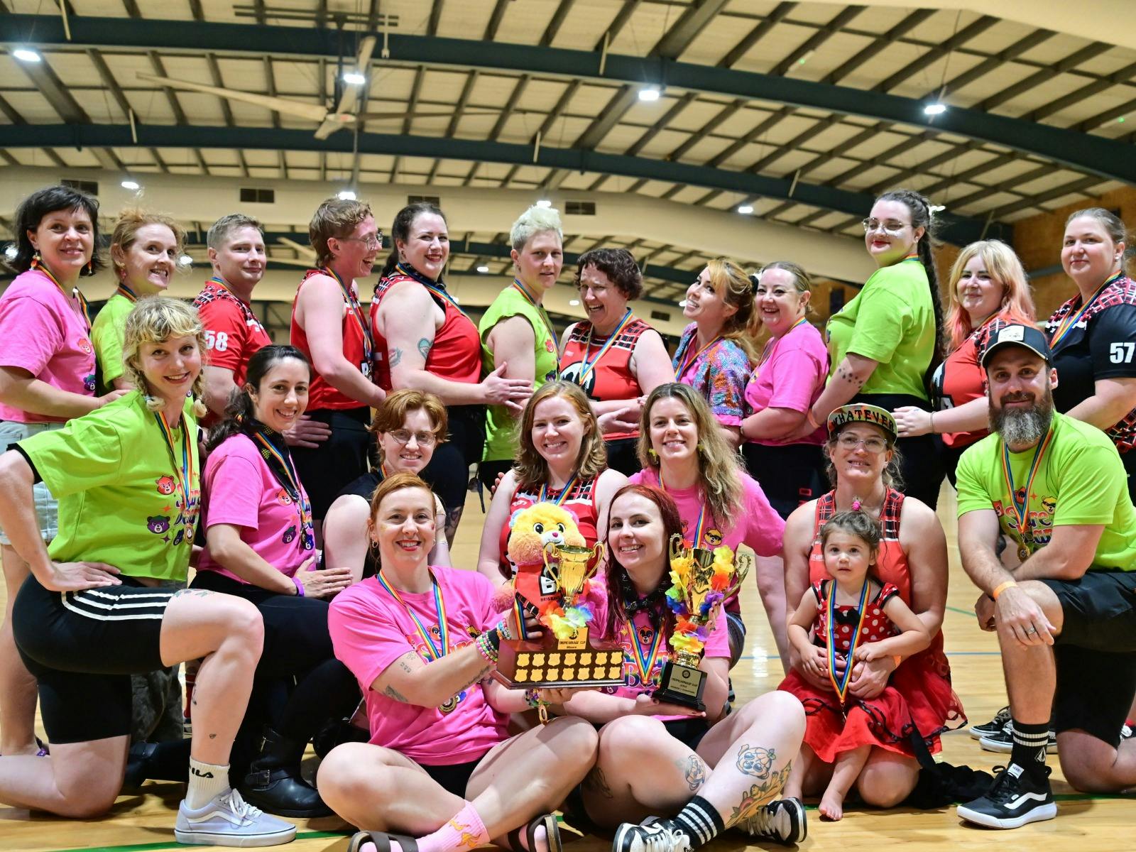 A group of roller derby skaters showing their colourful trophies. The skaters wear bright colours