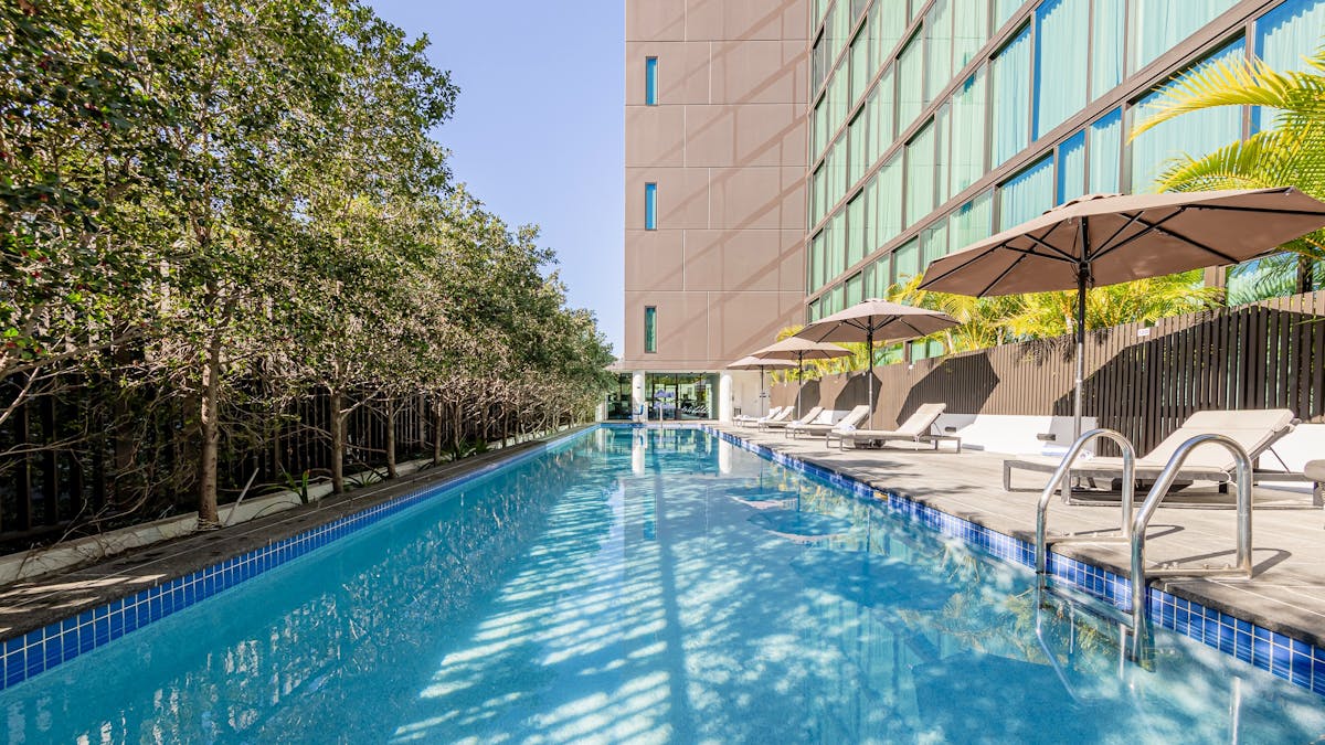 20-meter outdoor pool with sun lounges and sun umbrelas