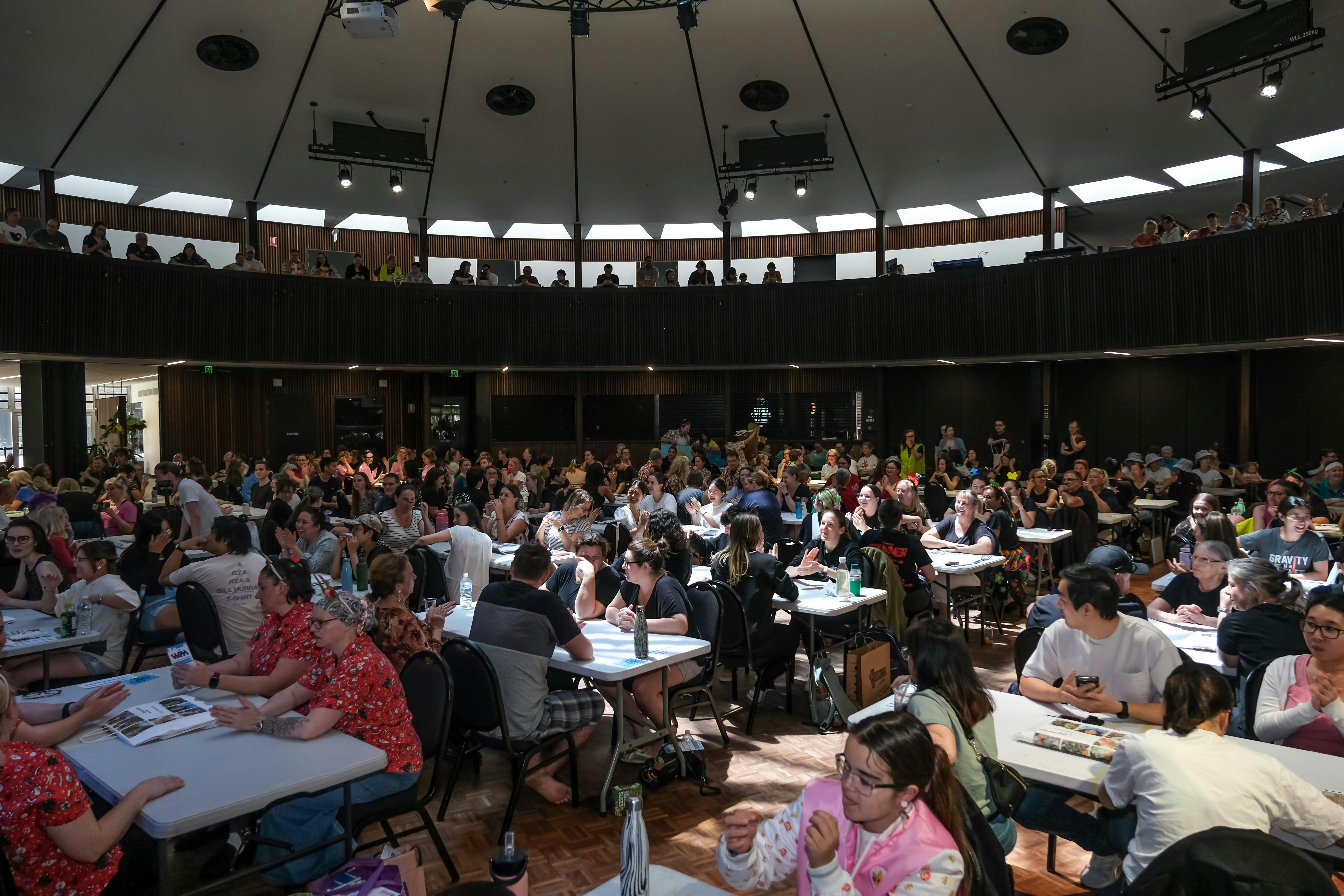 A large room with lots of people sitting at tables