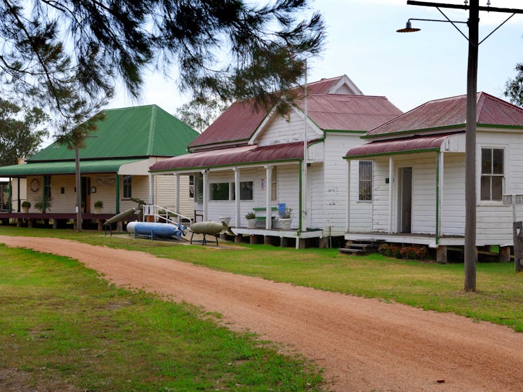 Three buildings on right with gravel pathway running in front of them