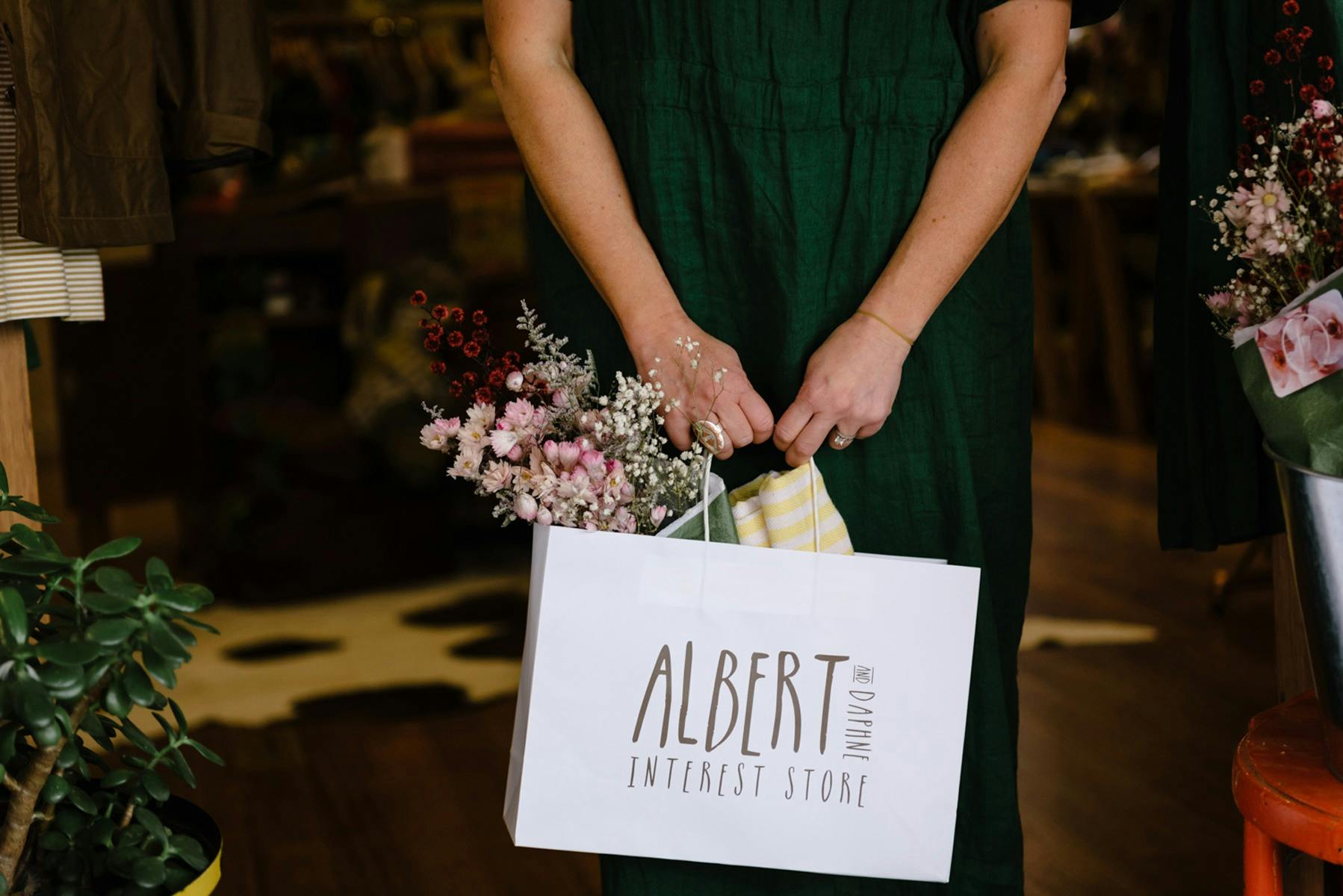 Albert and Daphne. Bag with retail products and flowers