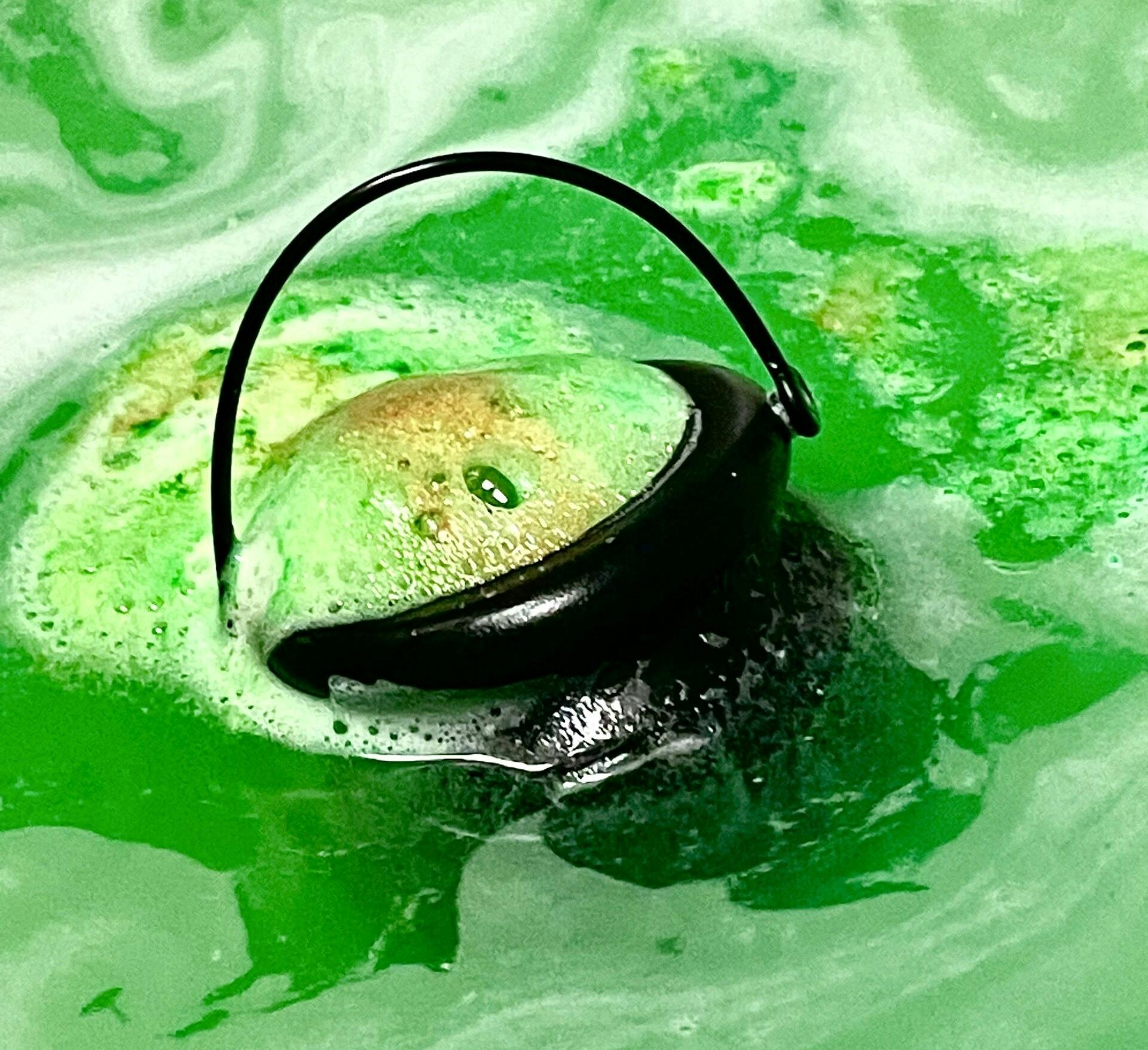 Bath bomb cauldron izzing green in water