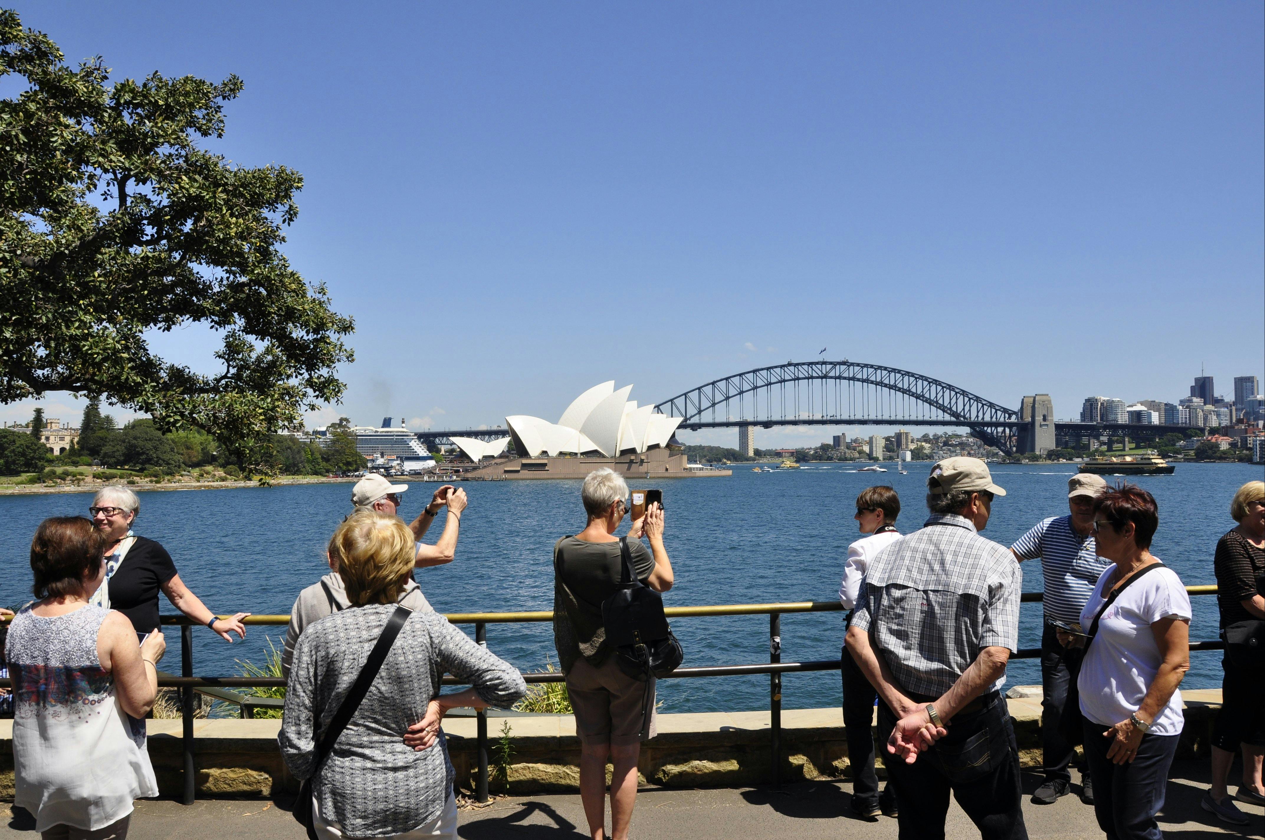 Sydney city tour bus group is taking pictures of Sydney Opera House and Sydney Harbour Bridge