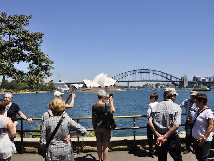 Sydney city tour bus group is taking pictures of Sydney Opera House and Sydney Harbour Bridge