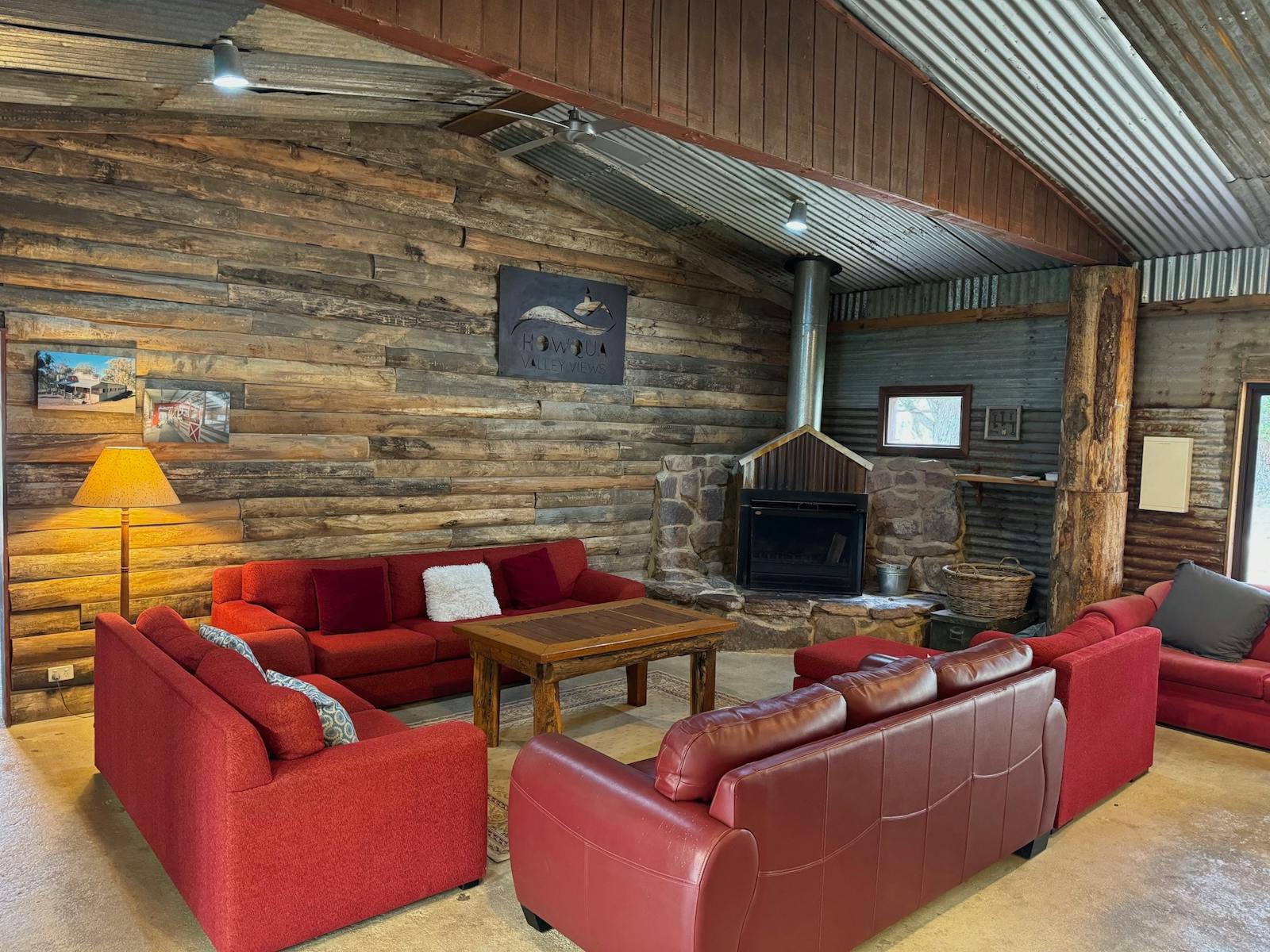 Several comfortable sofas in front of a large open fireplace