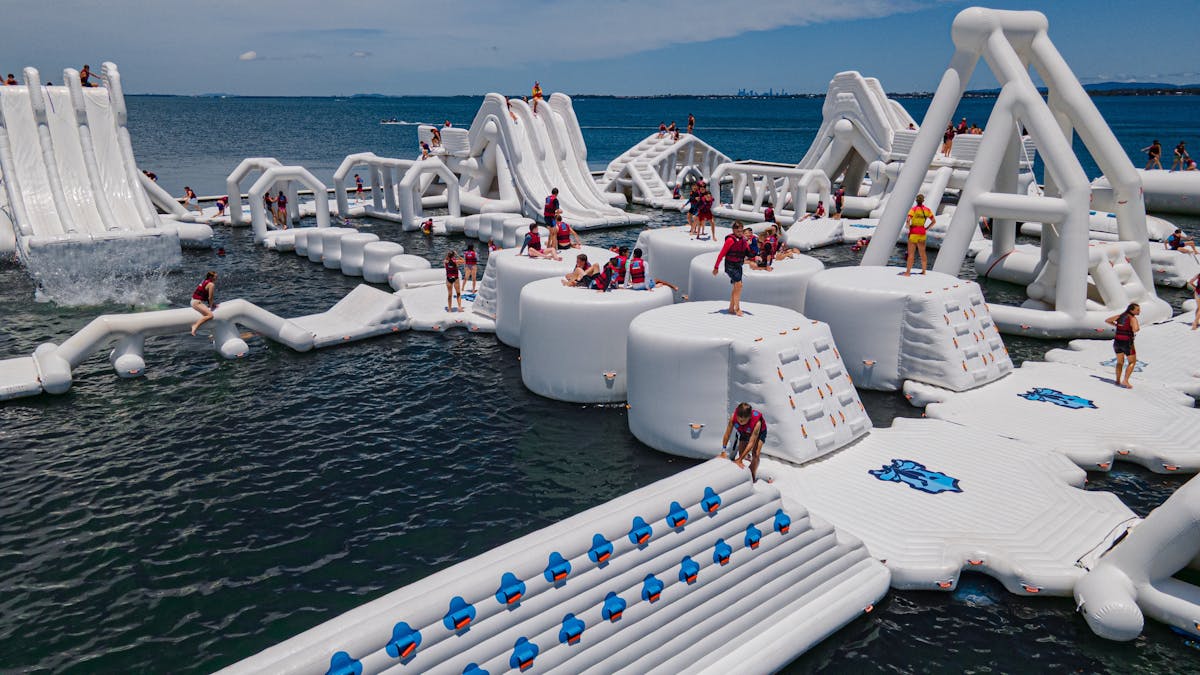 Image of inflatable water park with people playing on it