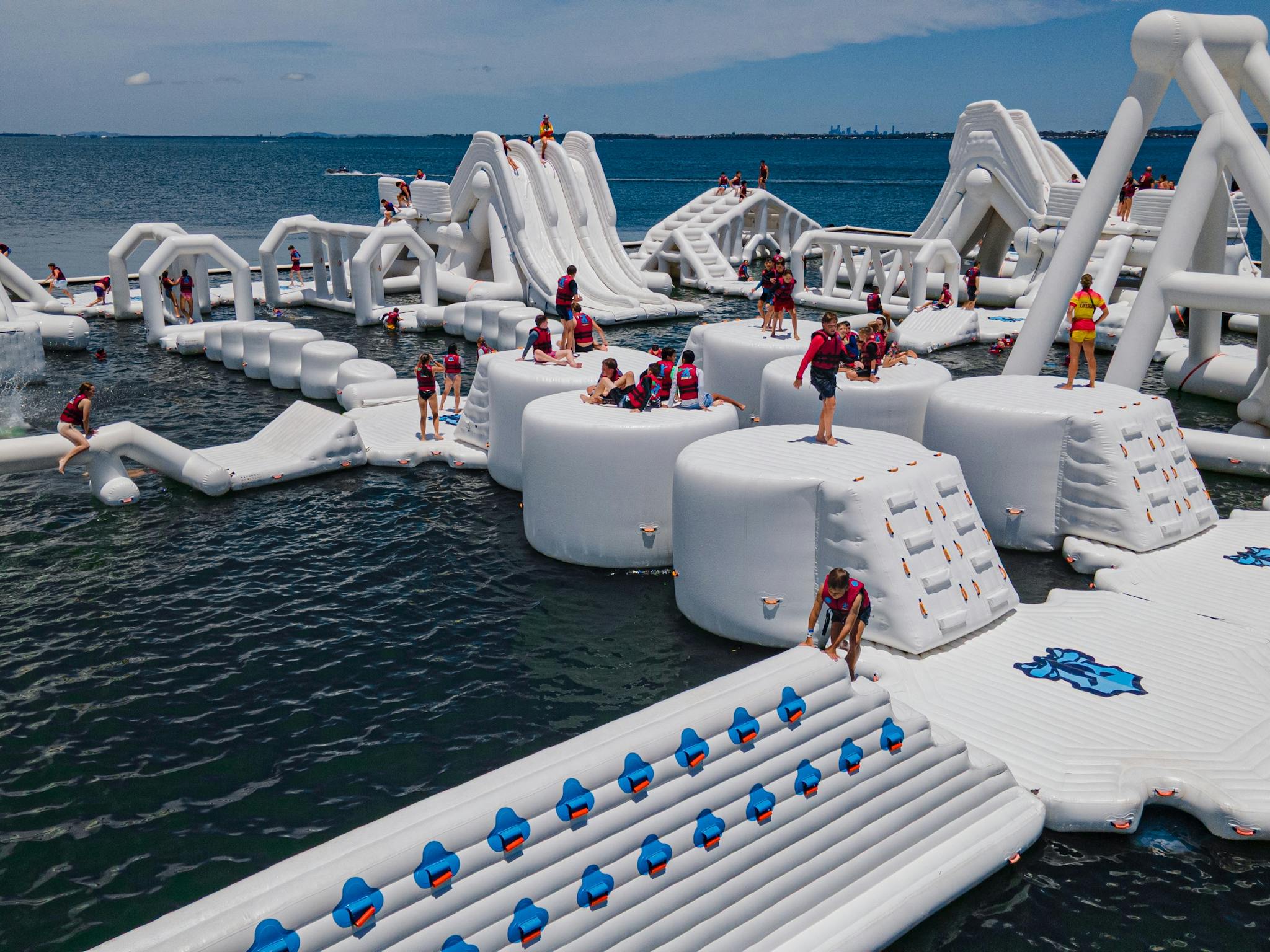 Image of inflatable water park with people playing on it Image of inflatable water park with people playing on it
