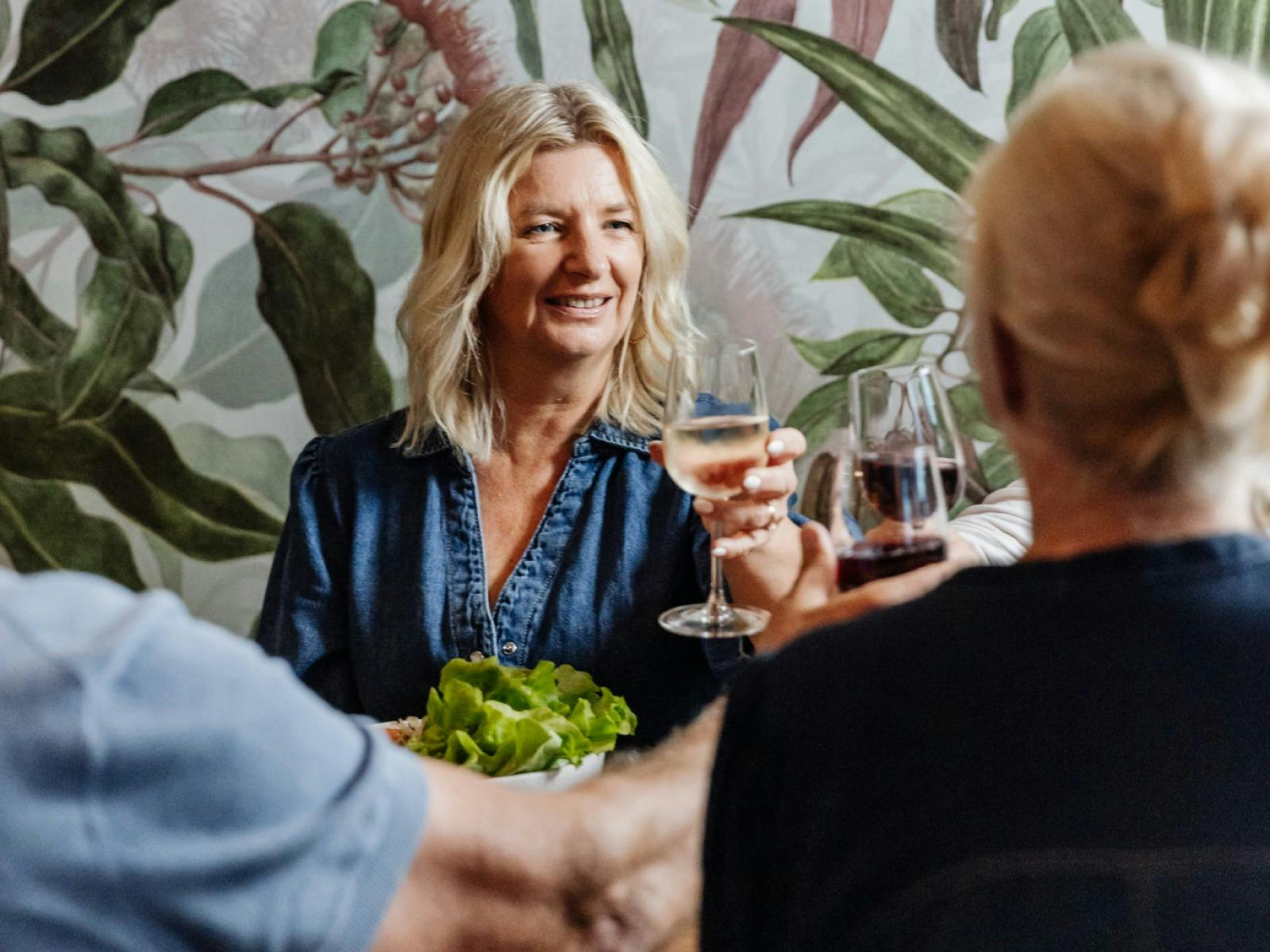 A group cheers to a mature looking smiling woman